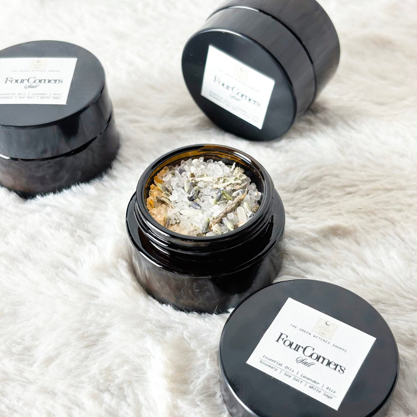Black containers with 'Four Corners' label on a white fluffy surface