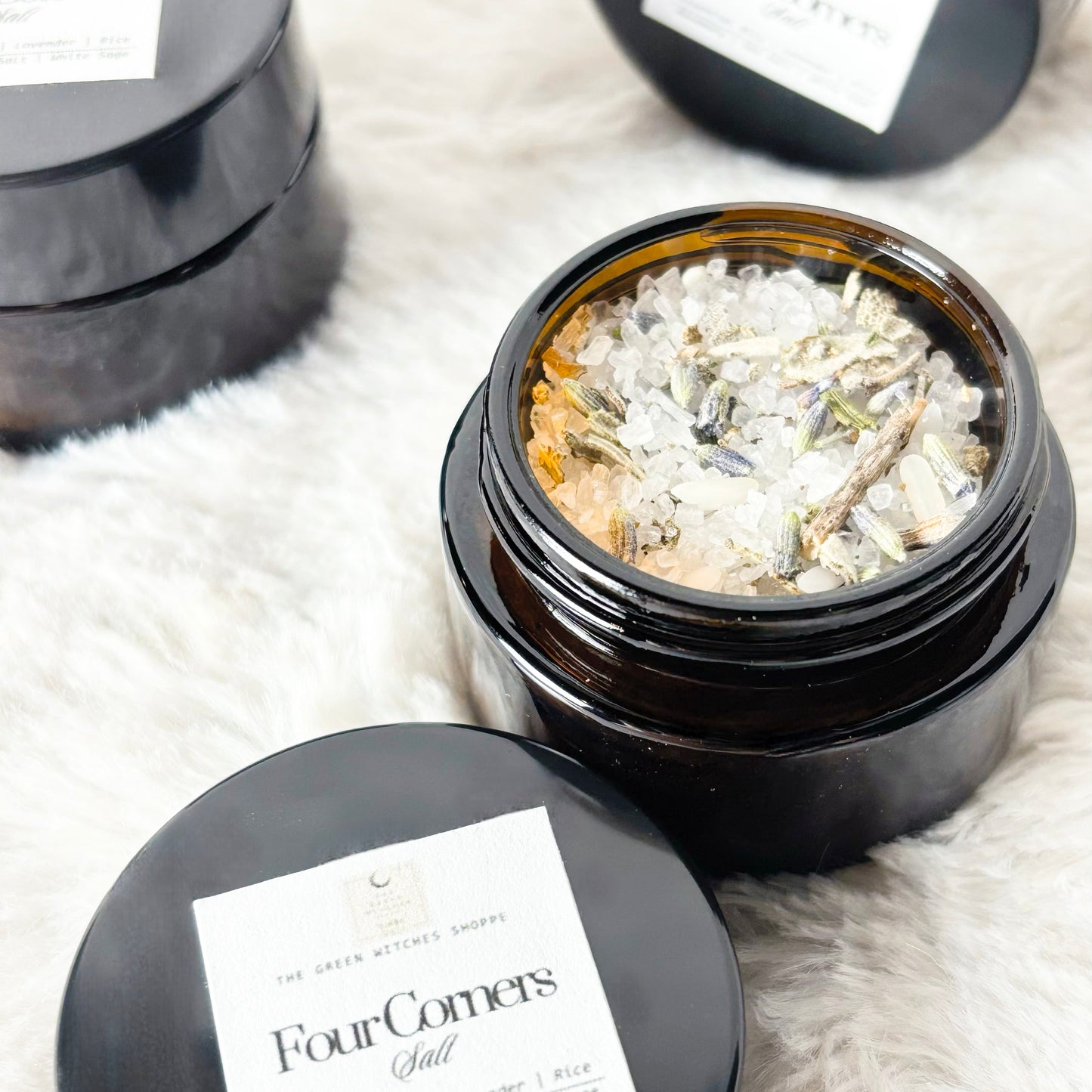 Black containers with 'Four Corners' label on a white fluffy surface