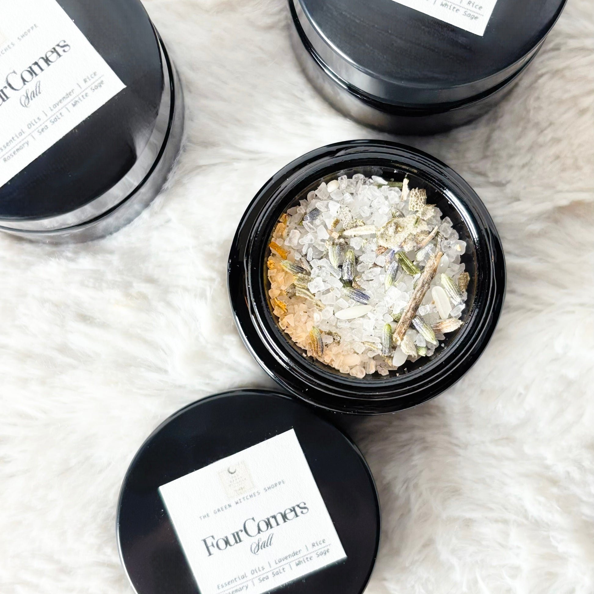 Black tins with 'Four Corners' label on a white textured surface
