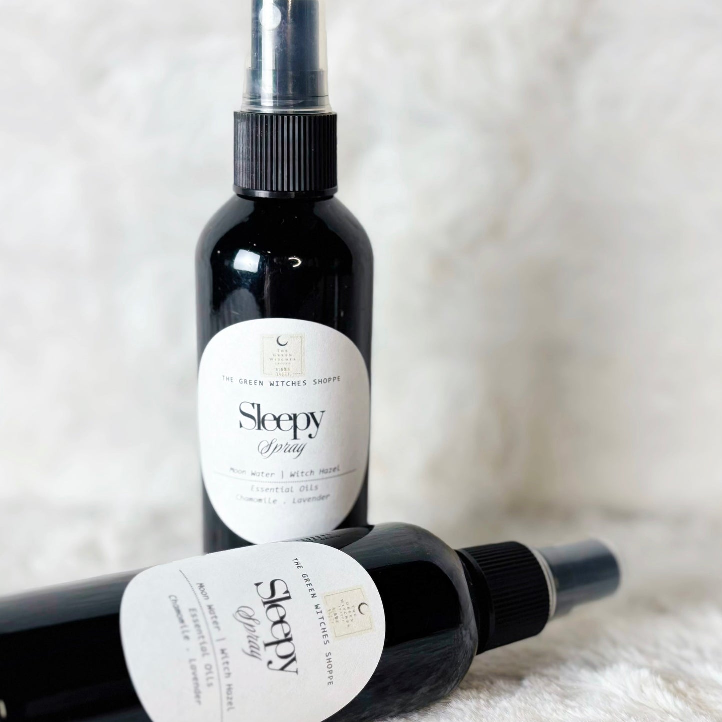 Two bottles of 'Sleepy' spray on a white surface