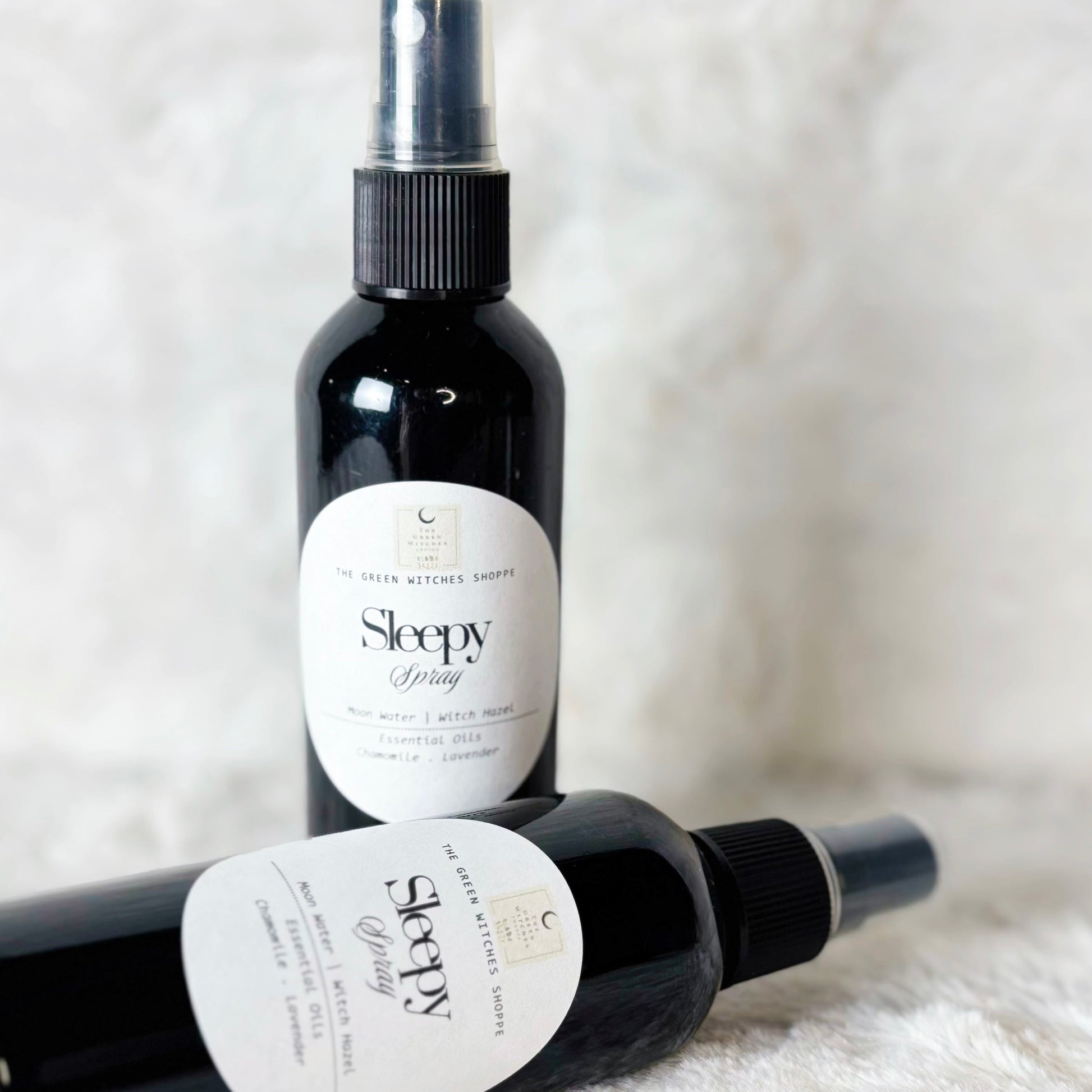 Two bottles of 'Sleepy' spray on a white surface