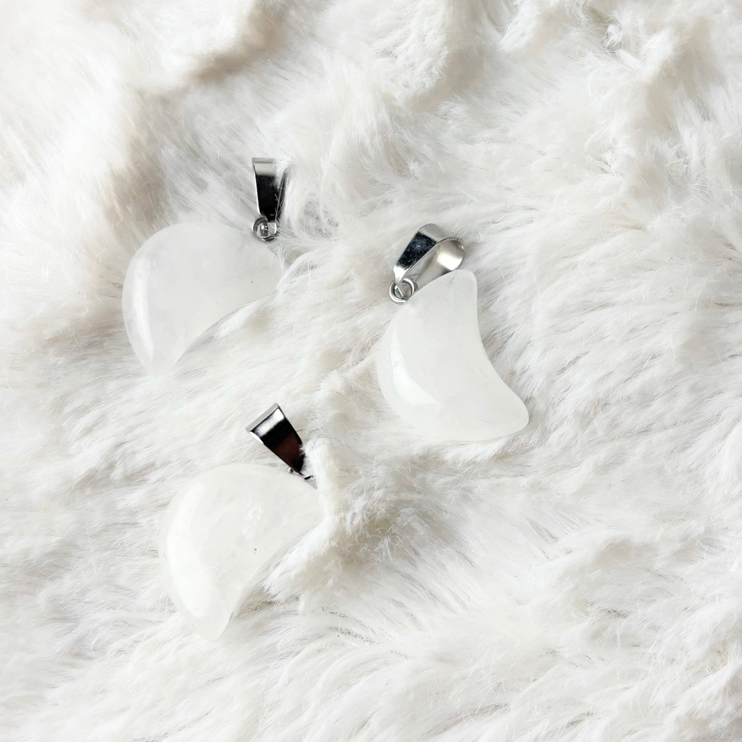 Silver necklace and earrings on a white fur surface