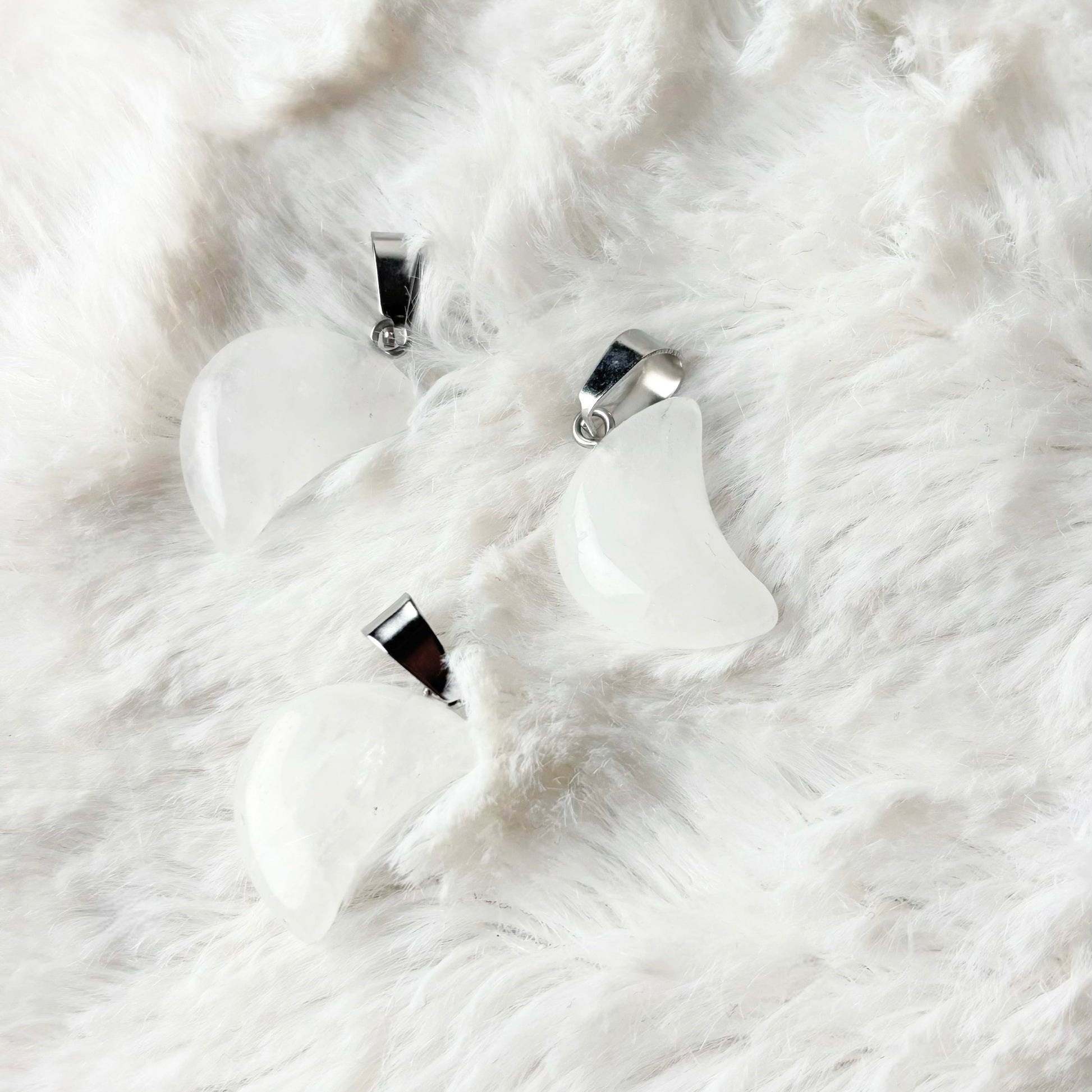 Silver necklace and earrings on a white fur surface