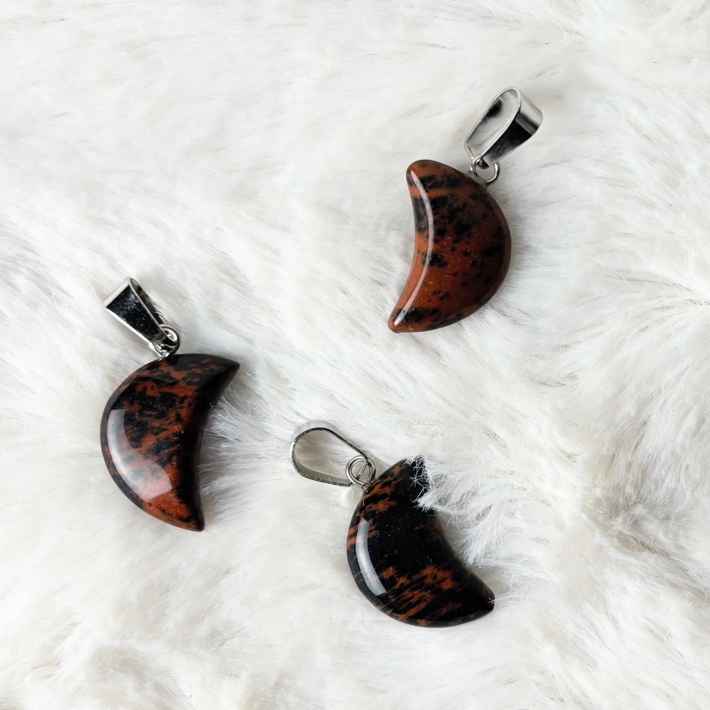 Three tortoiseshell pendants on a white textured surface