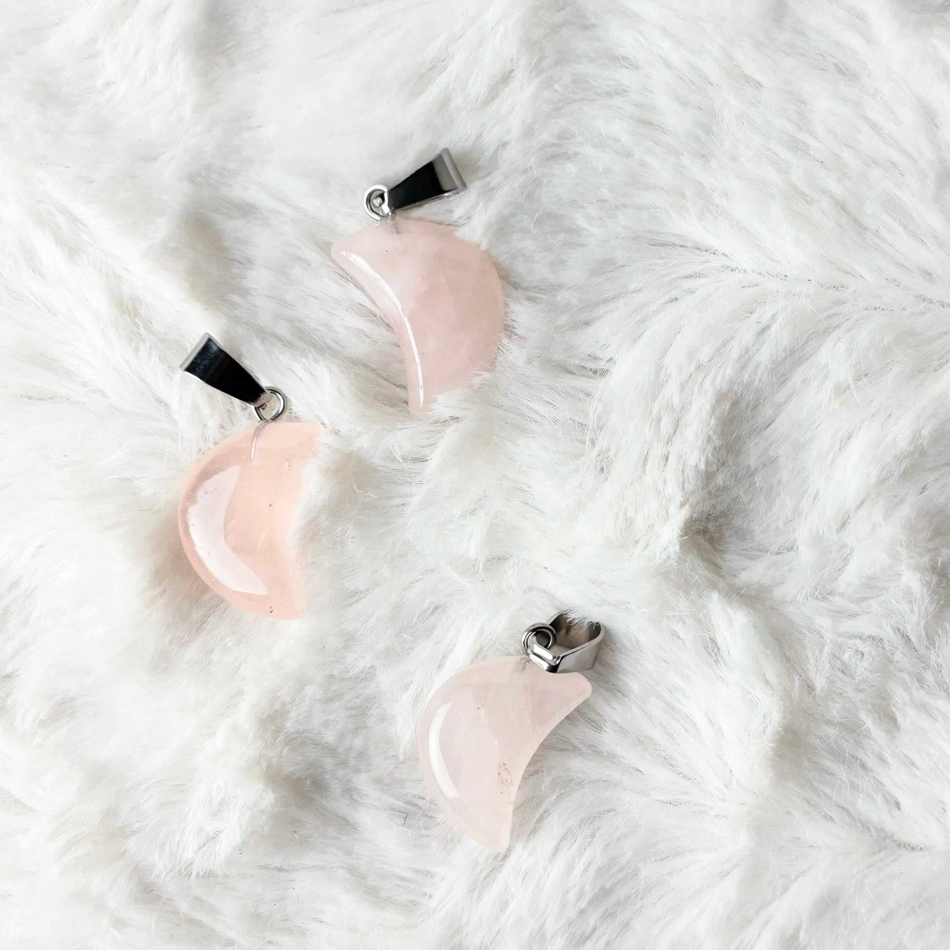 Pair of pink and silver earrings on a white textured surface