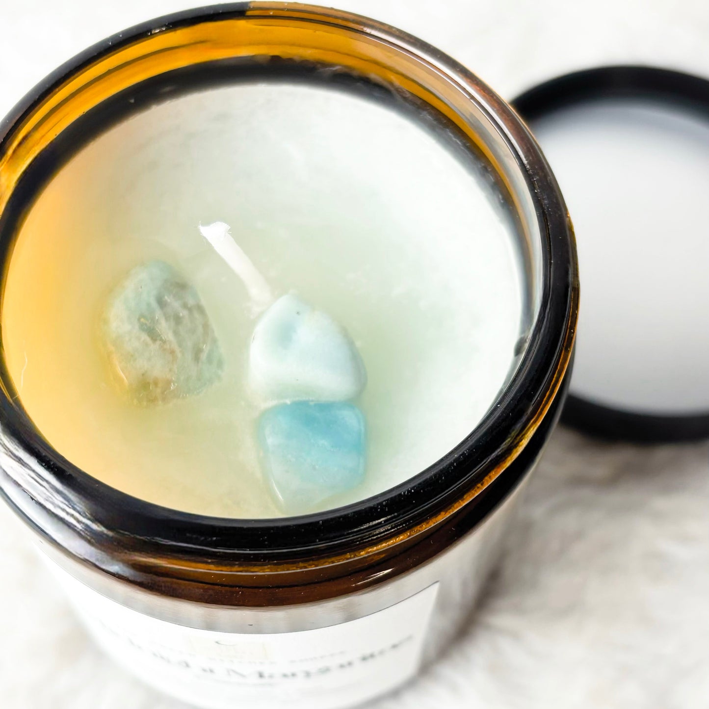 Candle in a glass jar with a black lid on a white background