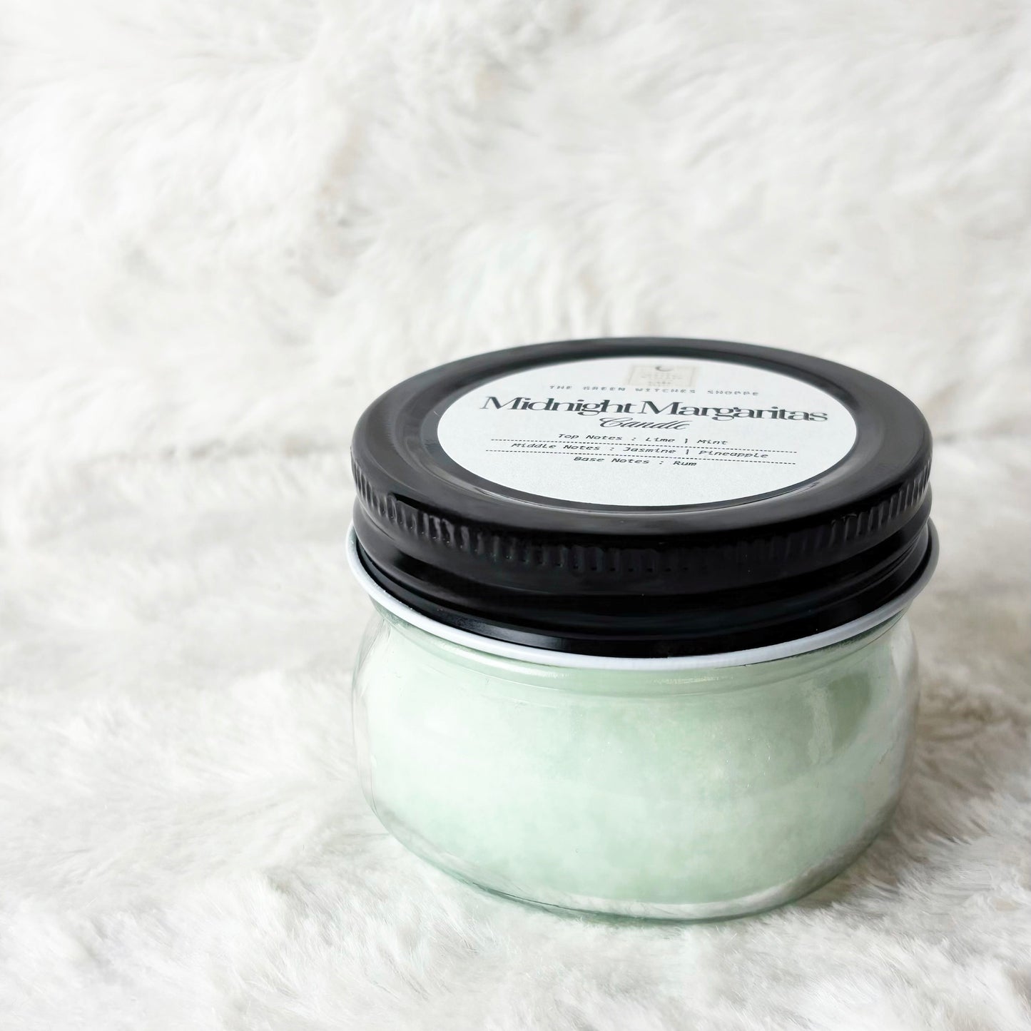 Jar of body scrub with black lid on a white textured background