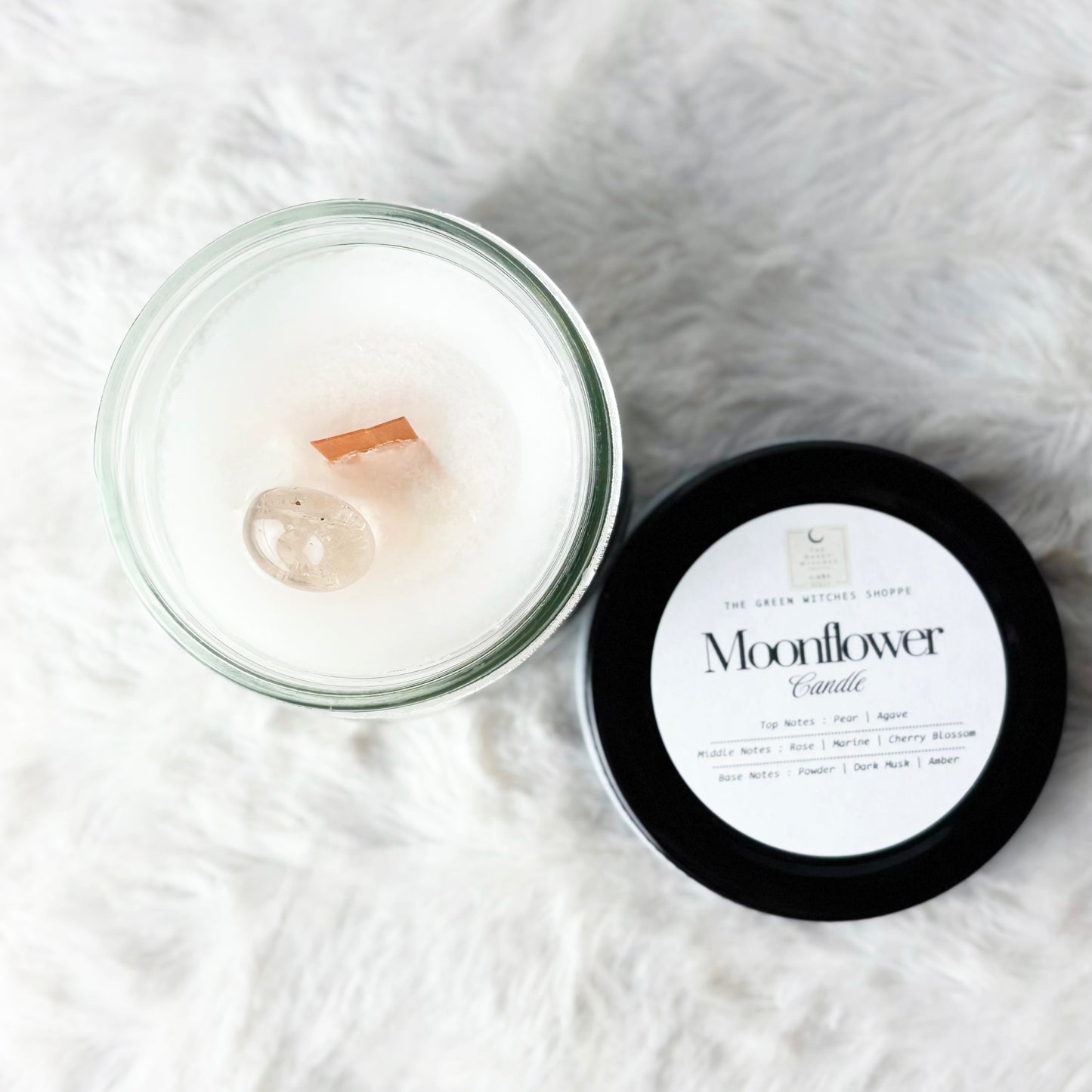 Moonflower candle with lid on a white textured surface