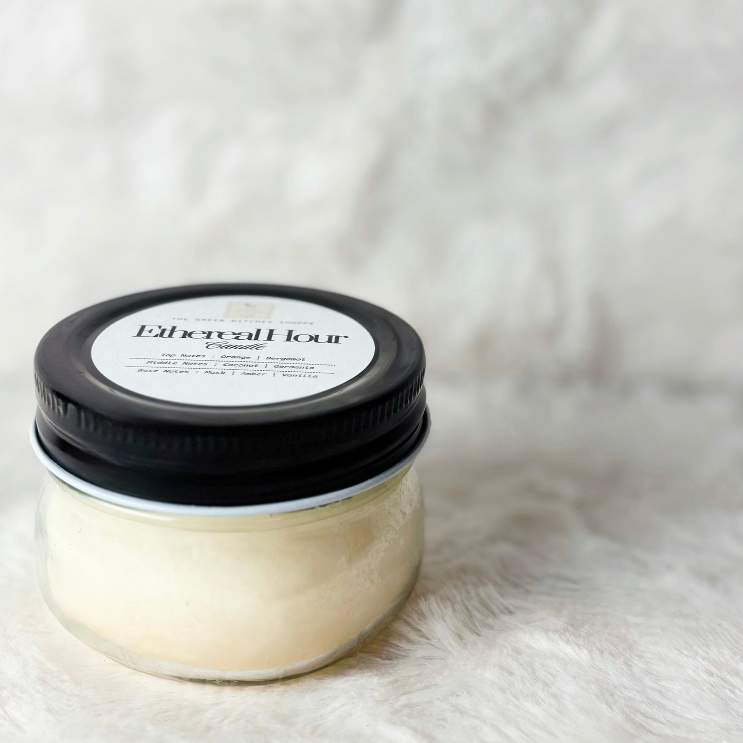 Jar of hair product with black lid on a white fur background
