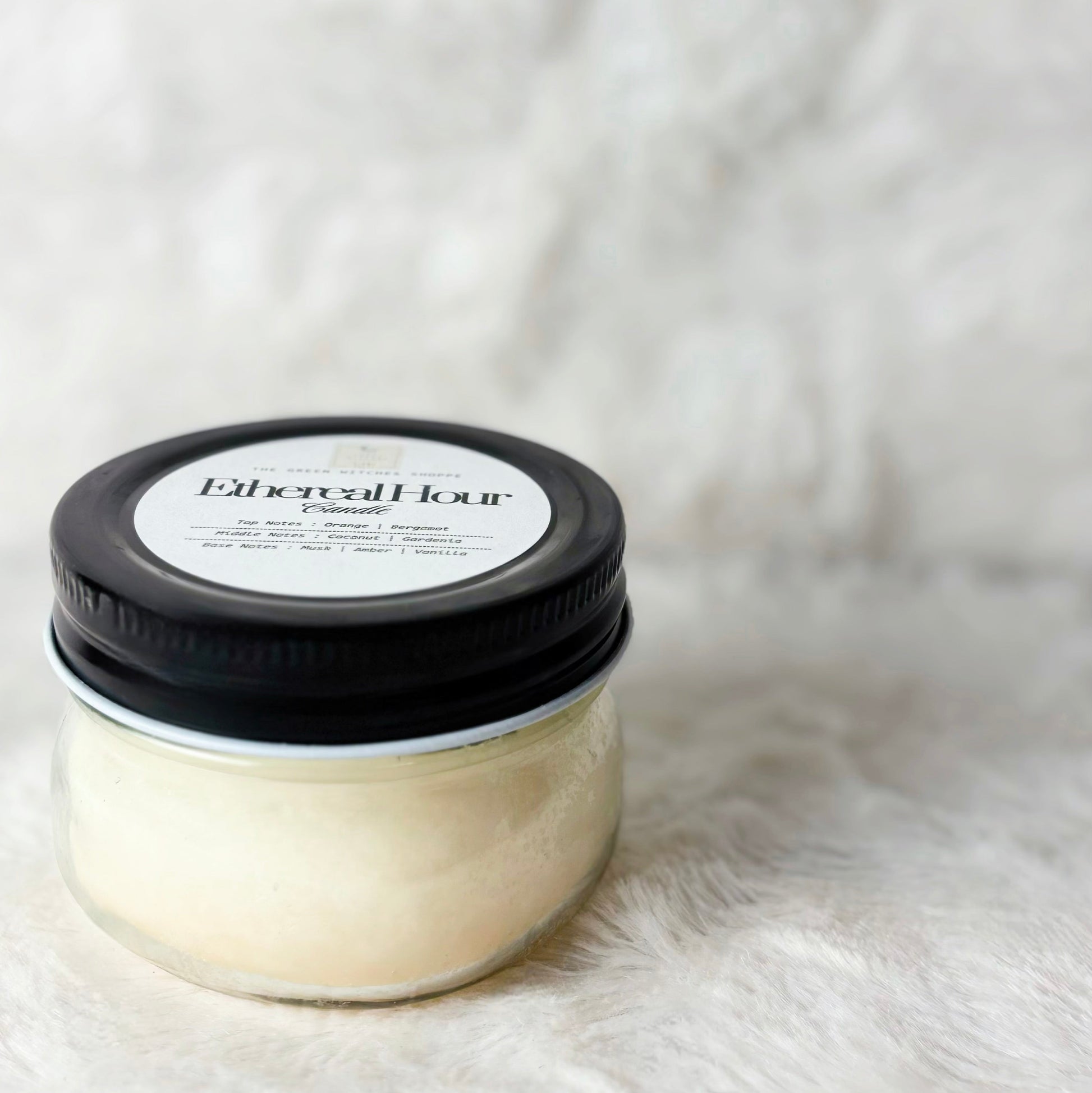 Jar of hair product with black lid on a white fur background