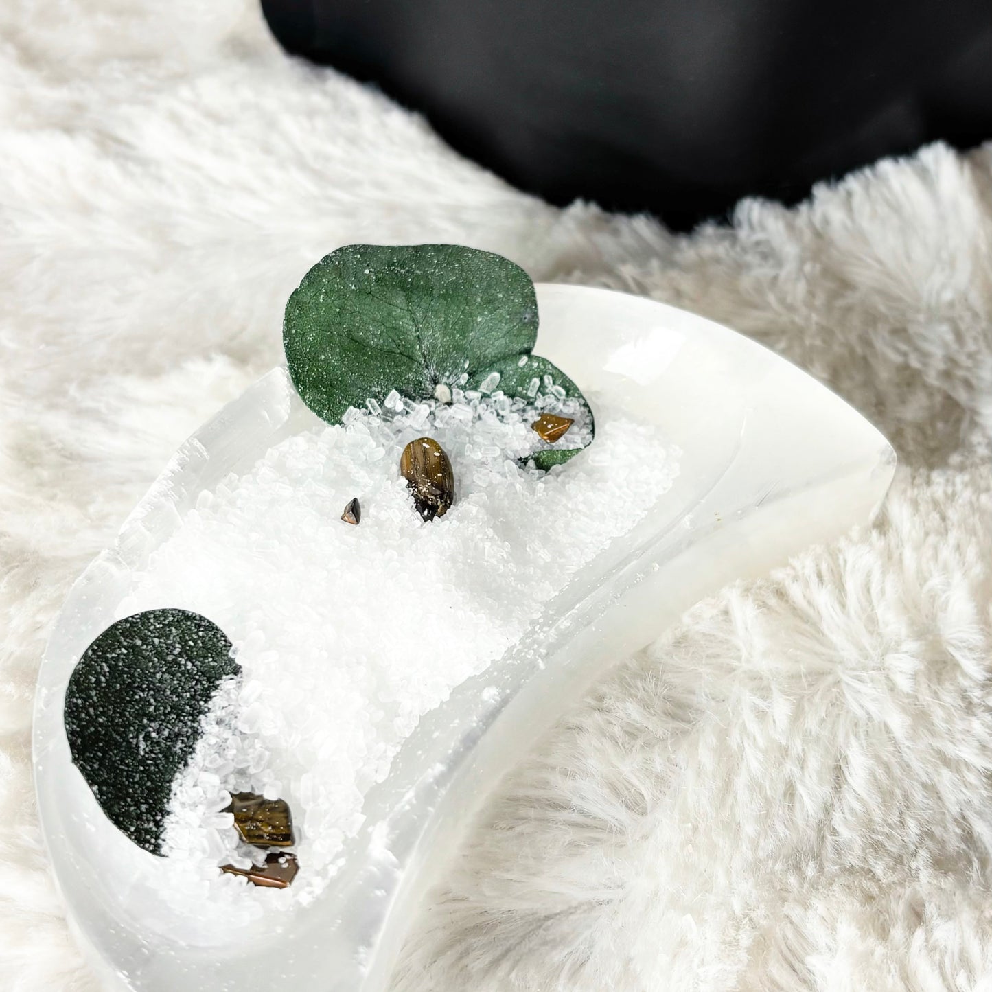 White ceramic dish with bath soak on a fluffy white surface