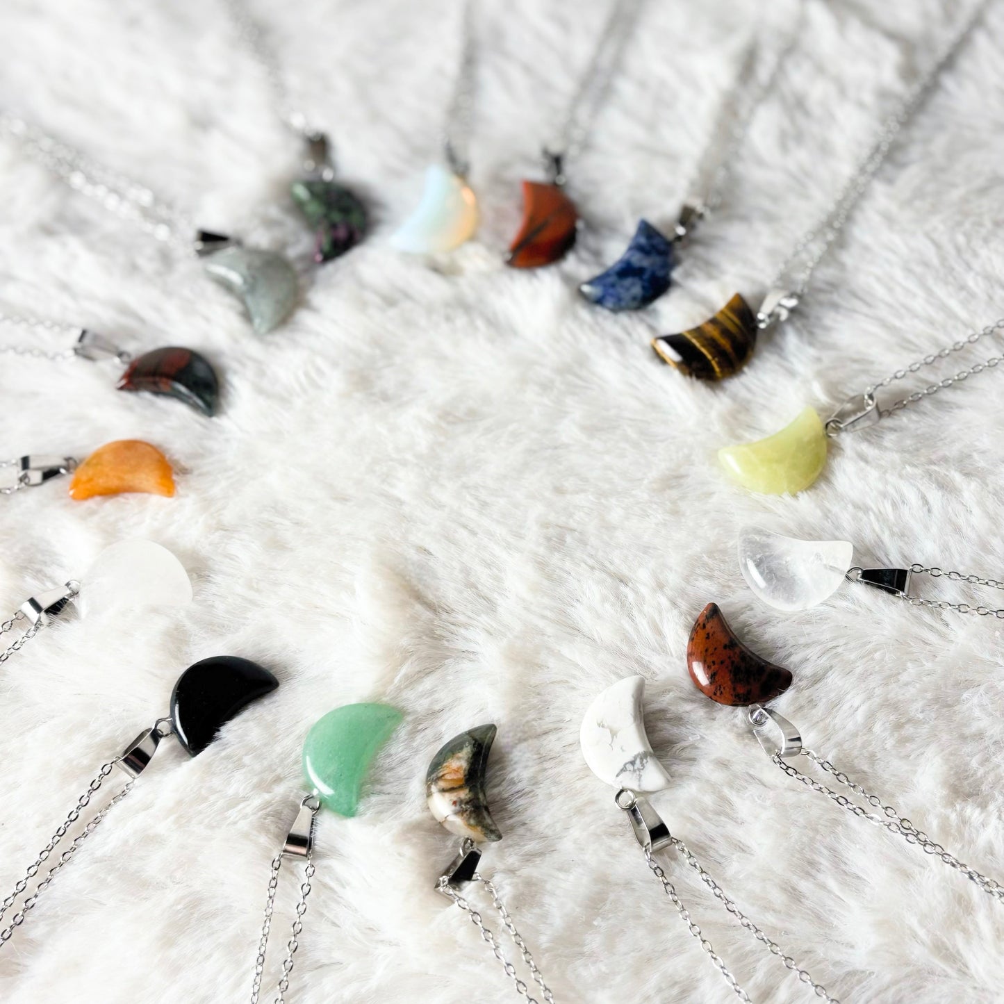 Necklaces with various colored pendants on a white textured surface