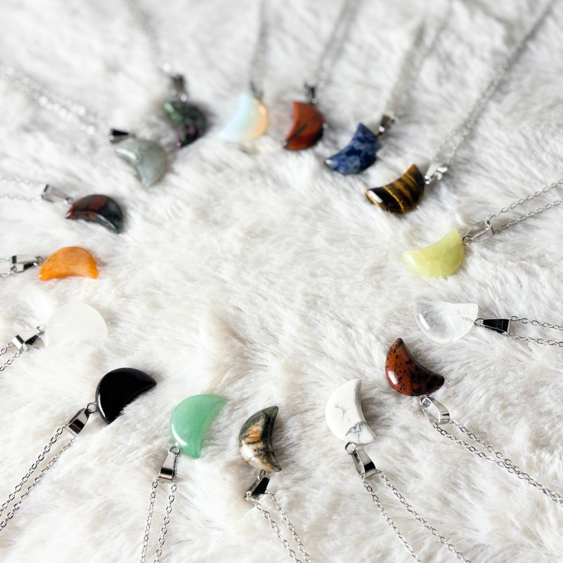 Necklaces with various colored pendants on a white textured surface