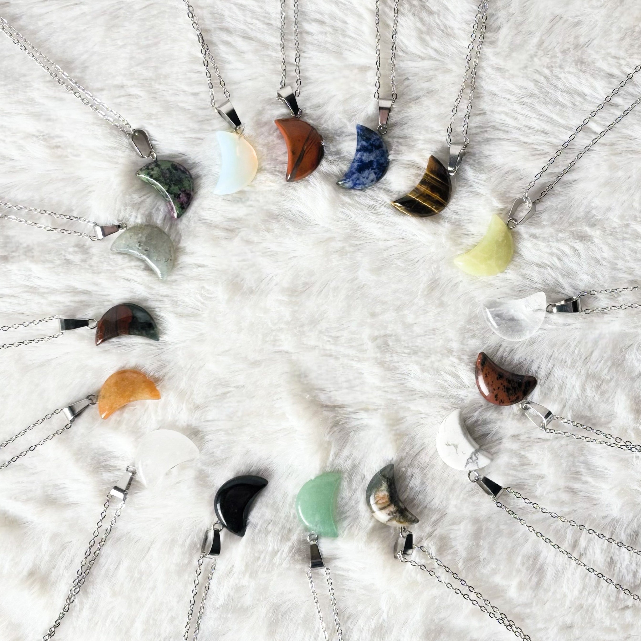 Necklaces with various colorful pendants on a textured white surface