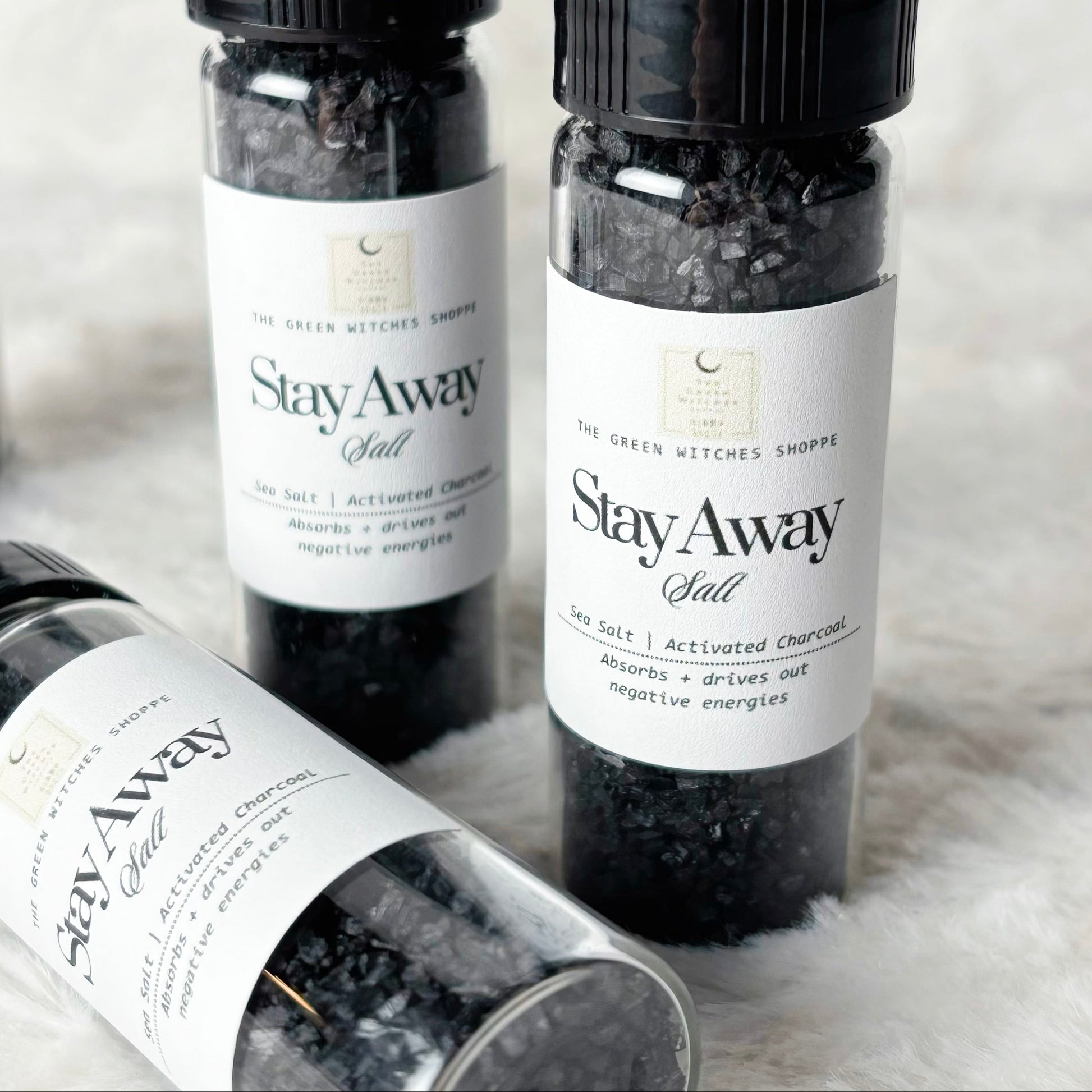 Four bottles of 'Stay Away Salt' on a textured surface