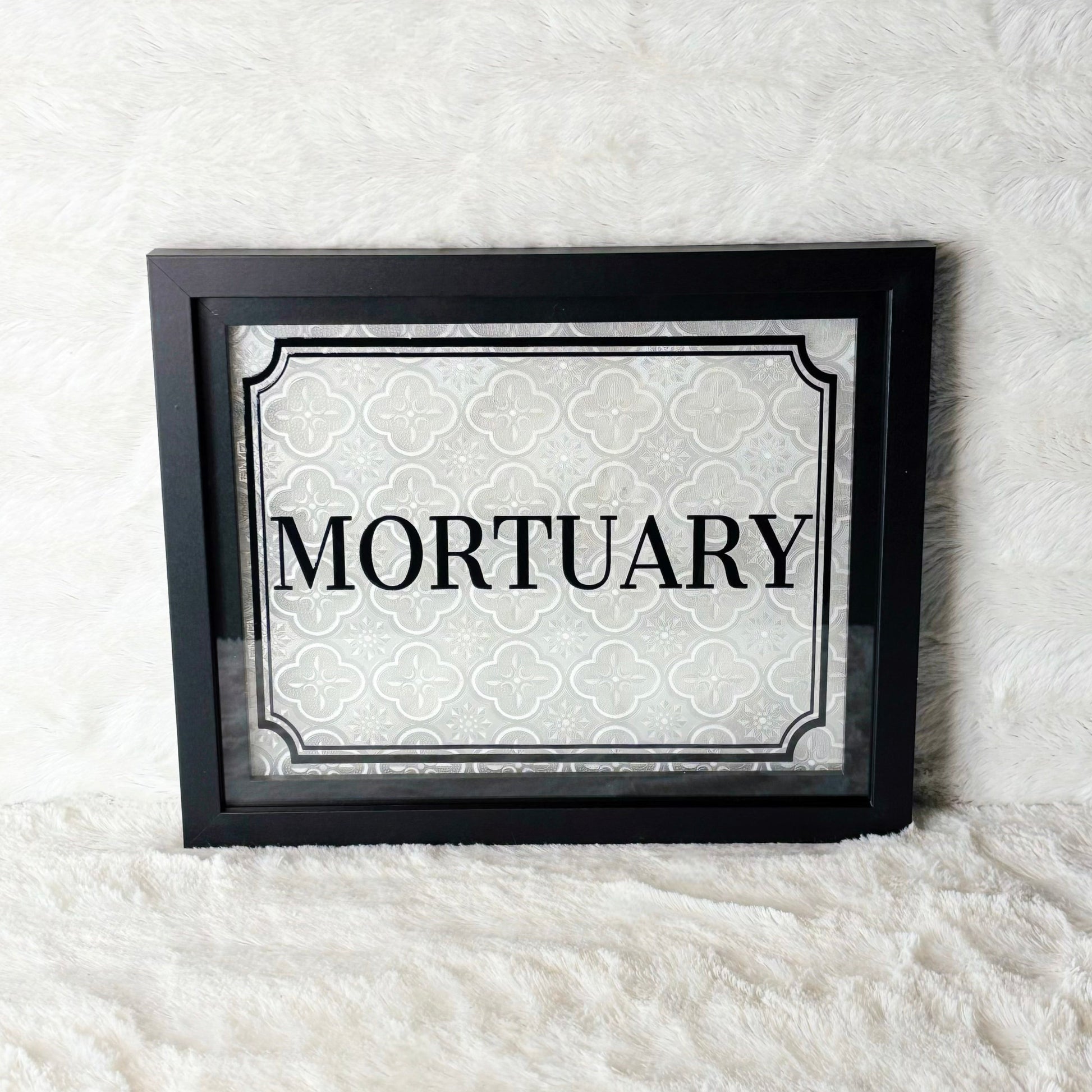 Framed sign with 'Mortuary' text on a white background