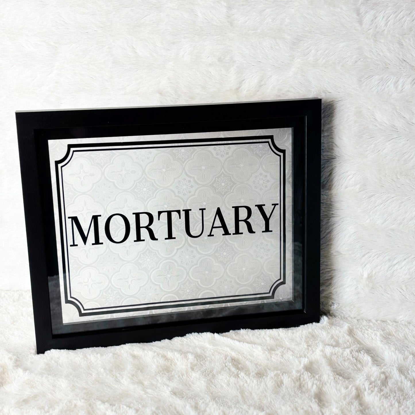 Framed sign with 'Mortuary' text on a white background