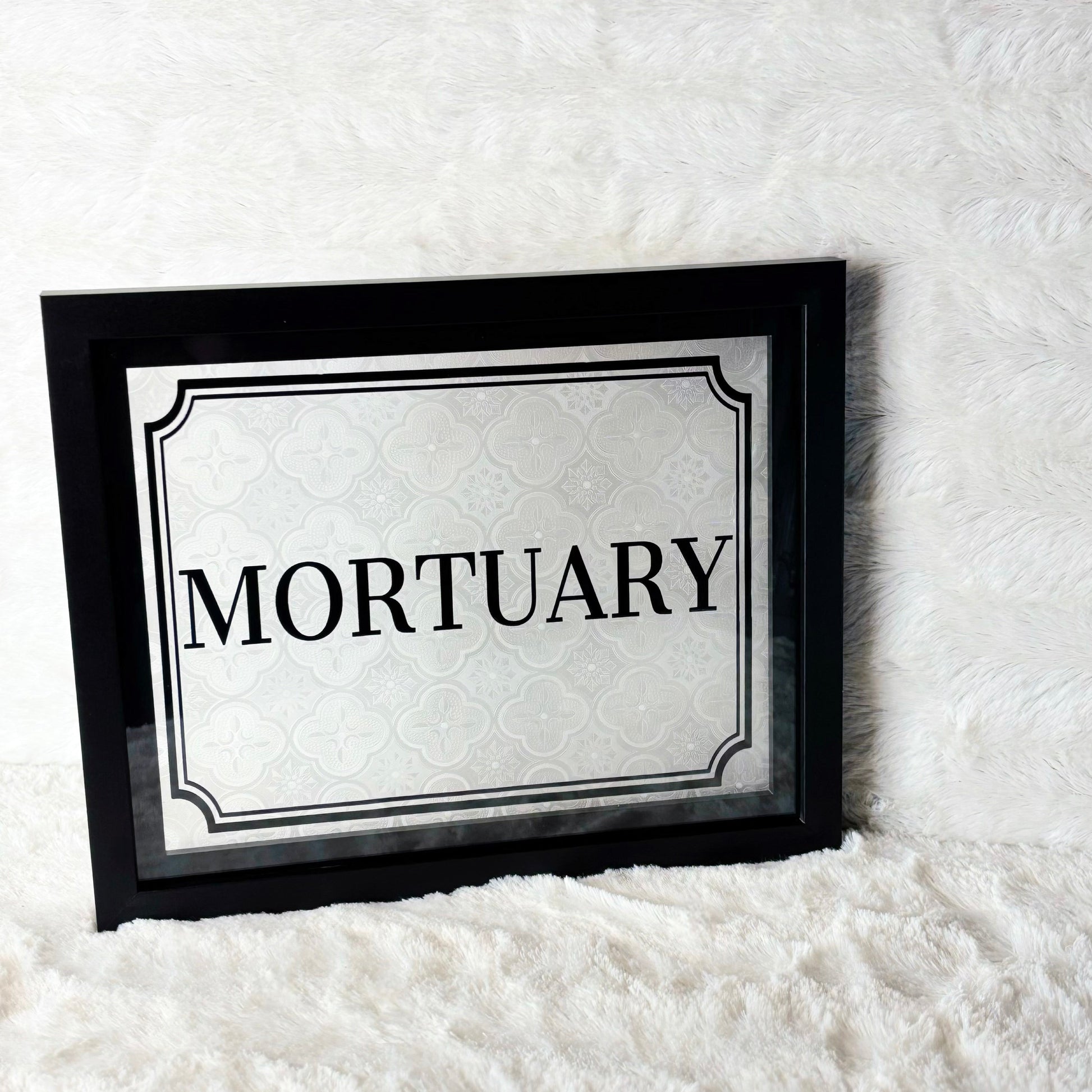 Framed sign with 'Mortuary' text on a white background
