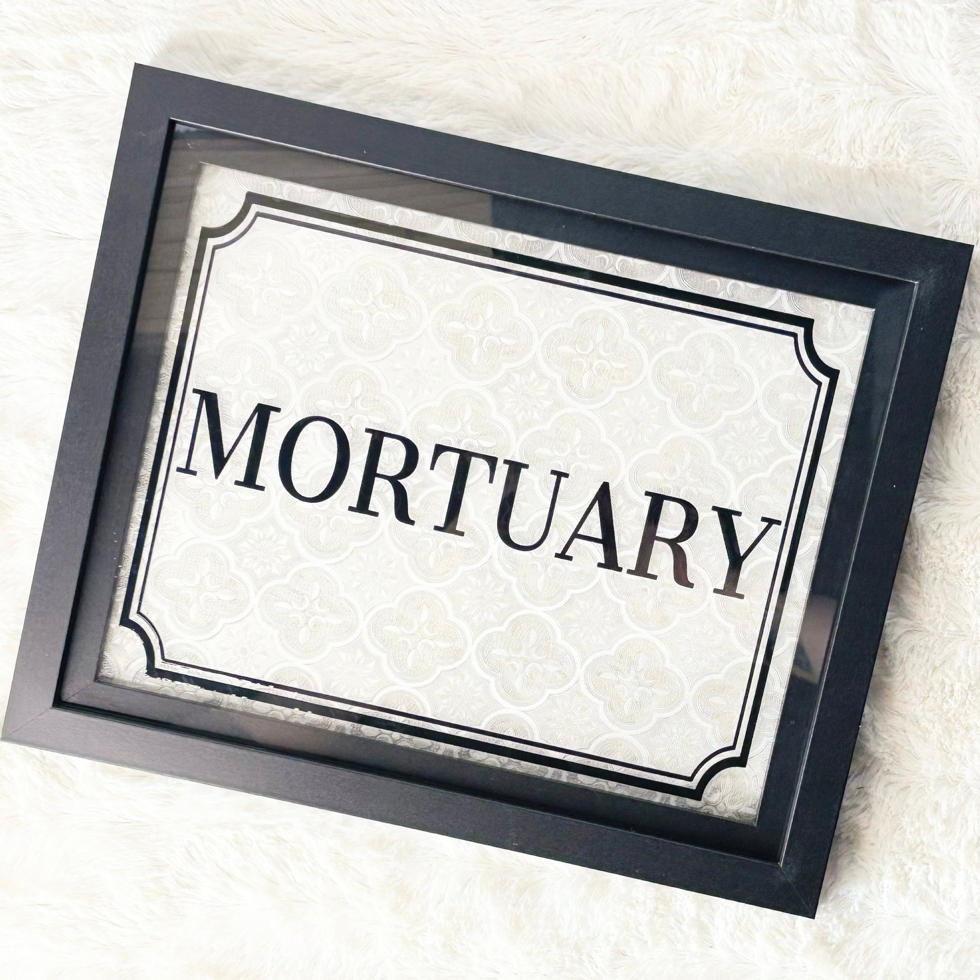 Framed sign with 'Mortuary' text on a white background