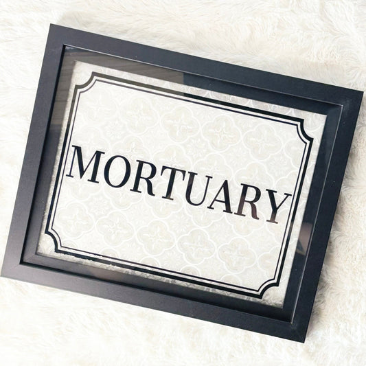 Framed sign with 'Mortuary' text on a white background