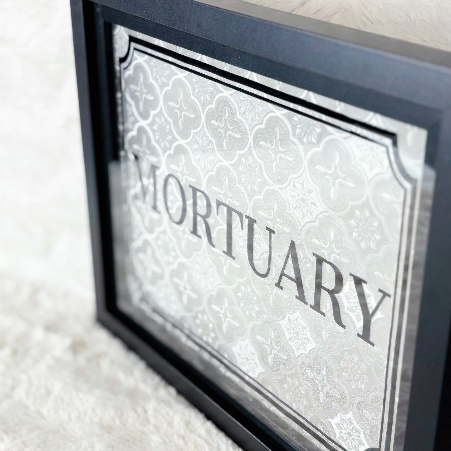 Framed sign with 'Mortuary' text on a white background