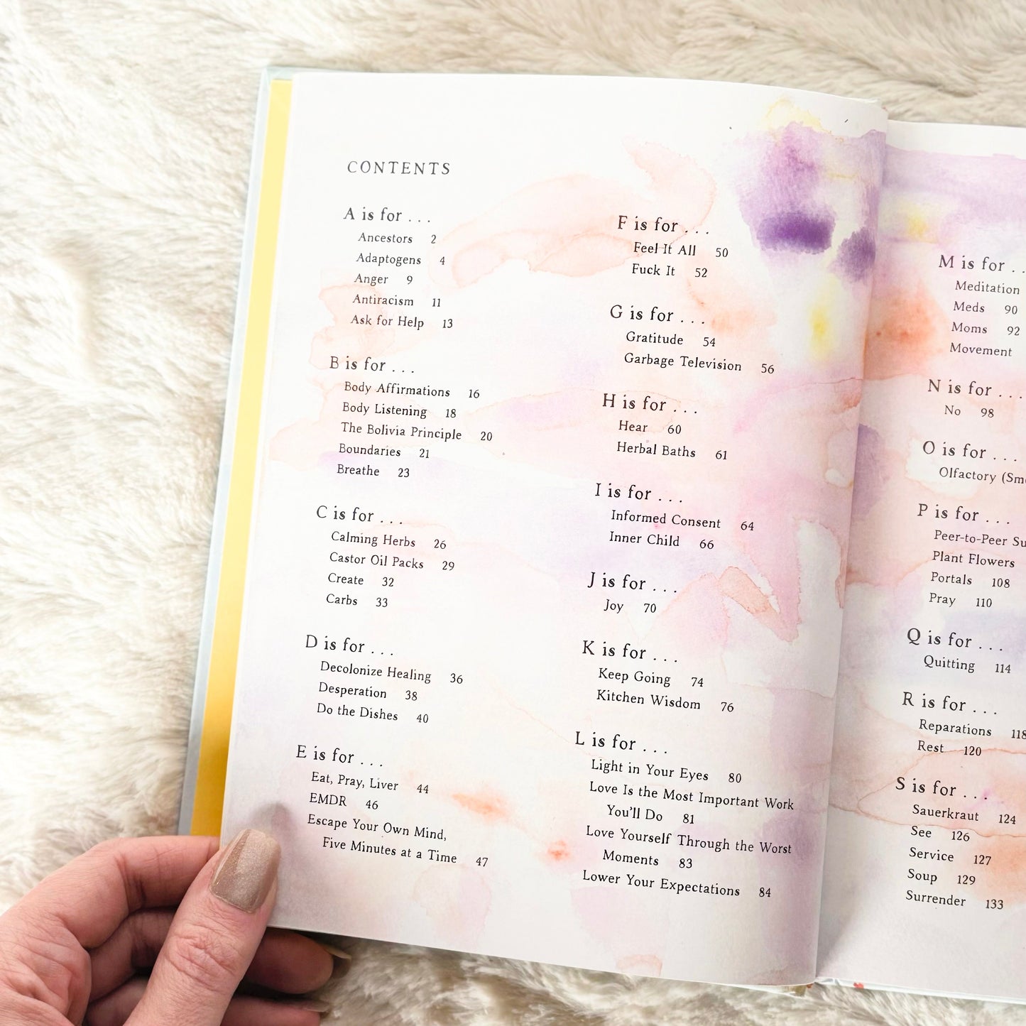 Open book with a colorful watercolor design on a fluffy white surface