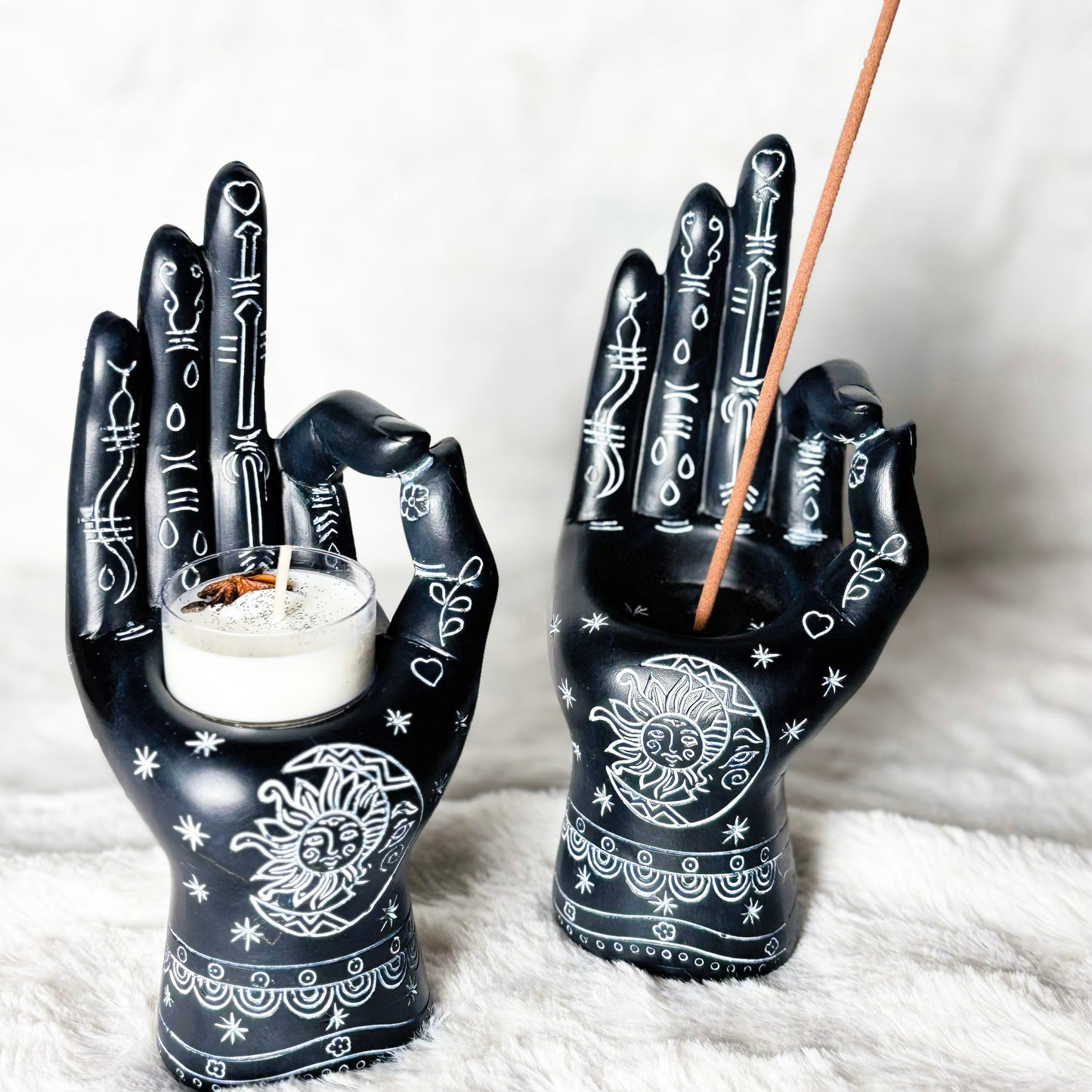 Decorative hands holding a candle and incense stick on a white background