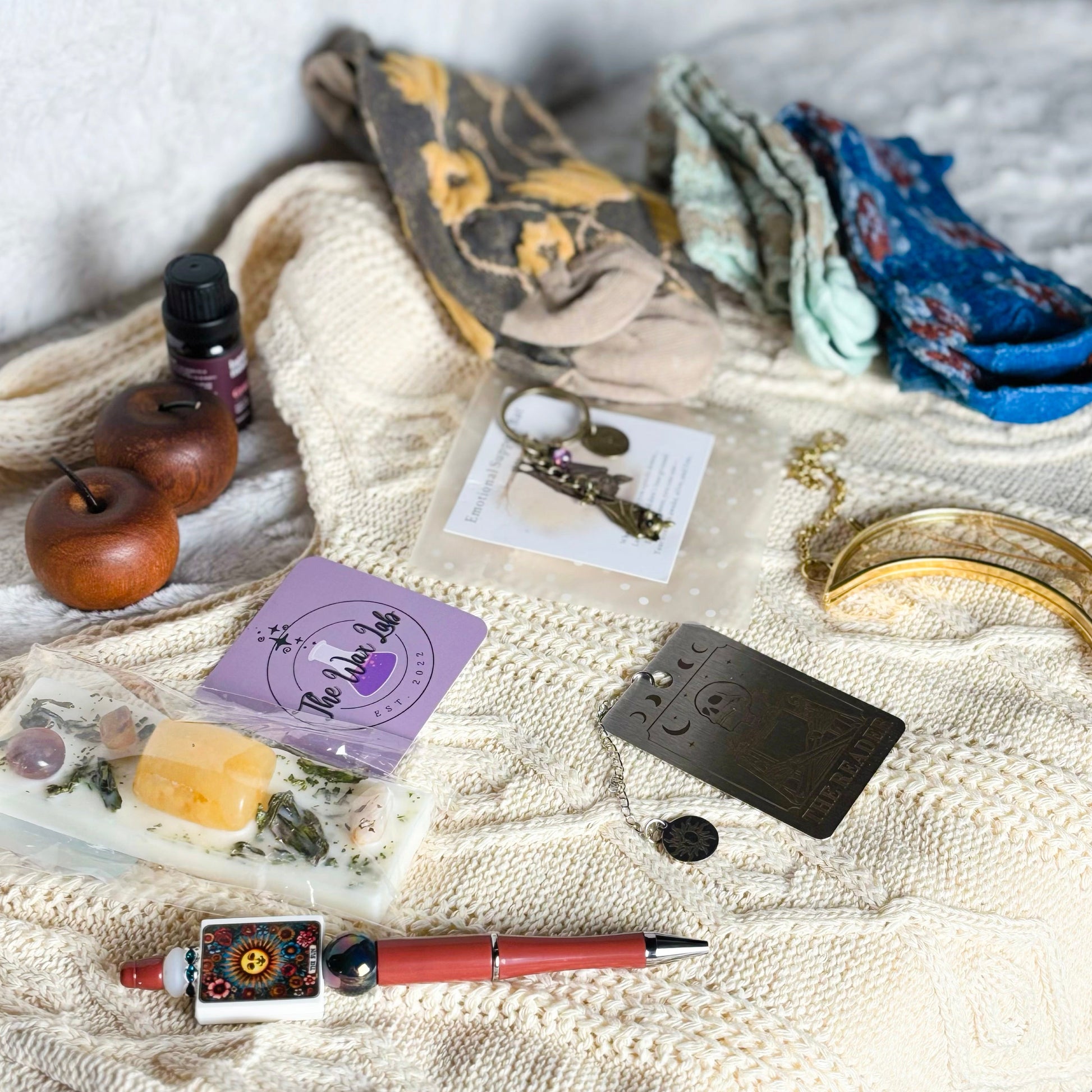 Collection of small items including a pen, cards, and decorative objects on a textured surface.