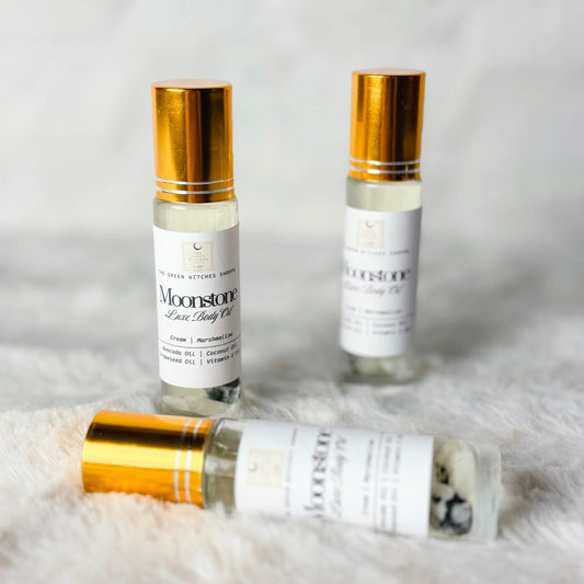 Three bottles of Moonstone Face Beauty Oil on a textured white surface