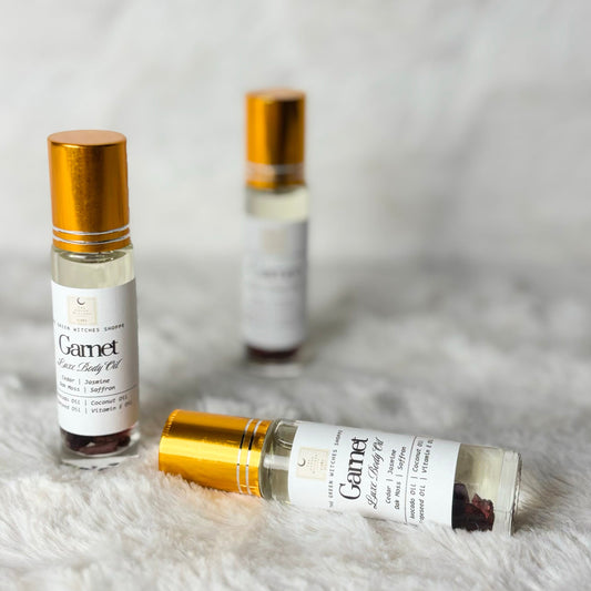 Three small bottles of Gamet Elixir Body Oil on a textured white surface
