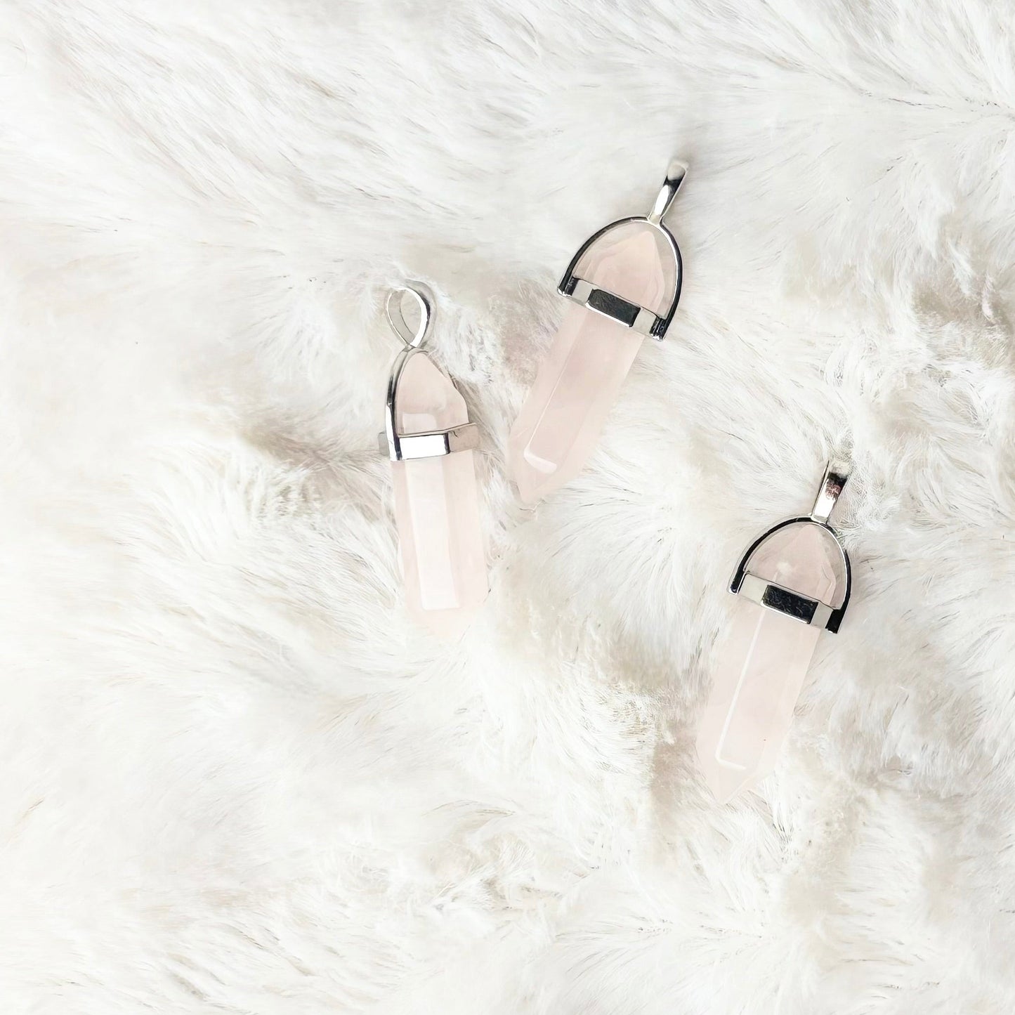 Three black and silver earrings on a white fur surface