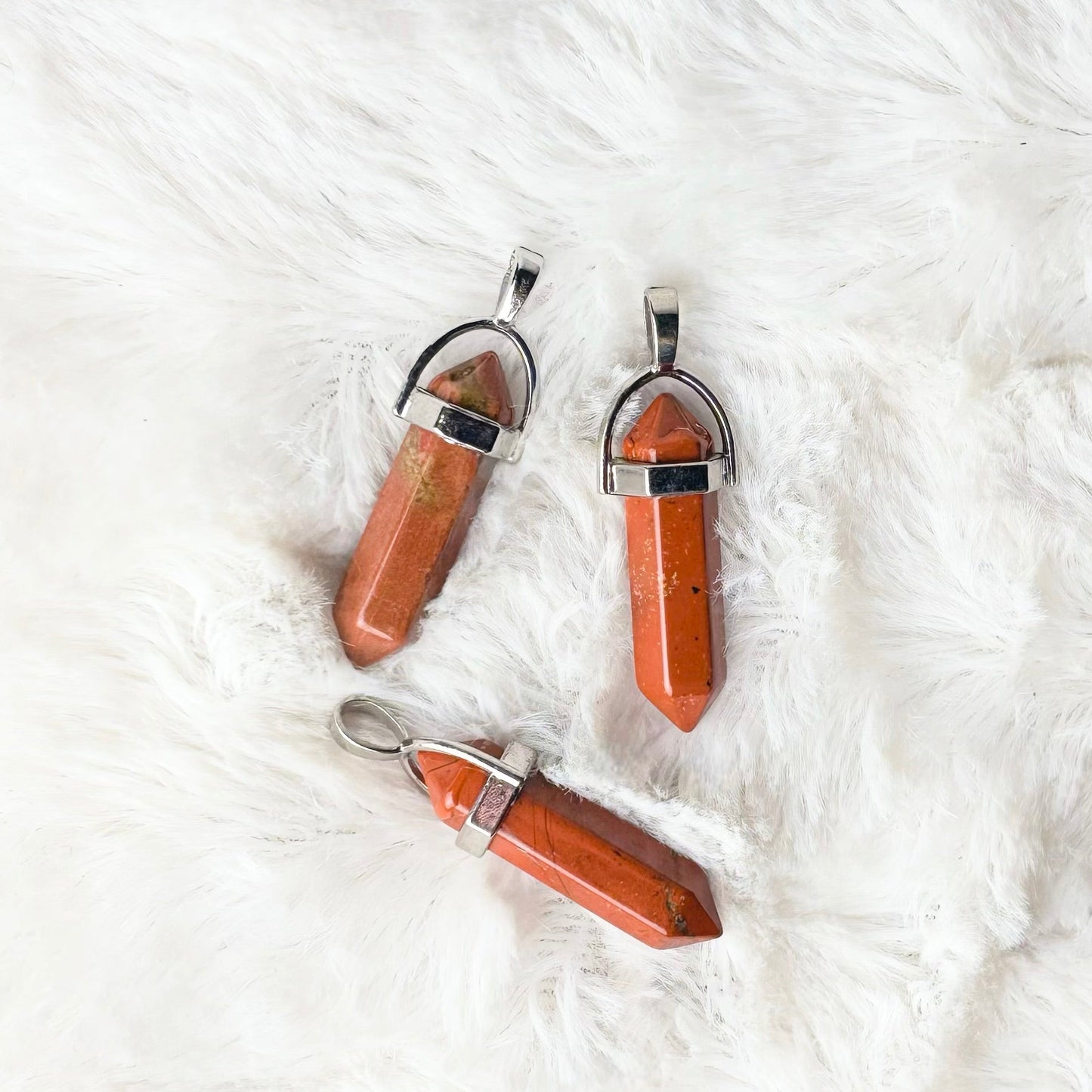 Three small bottles with caps on a white fluffy surface