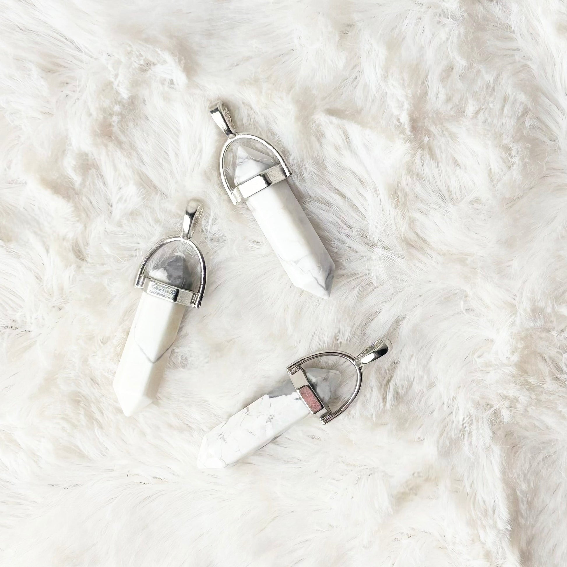 White stone pendants on a white fluffy surface