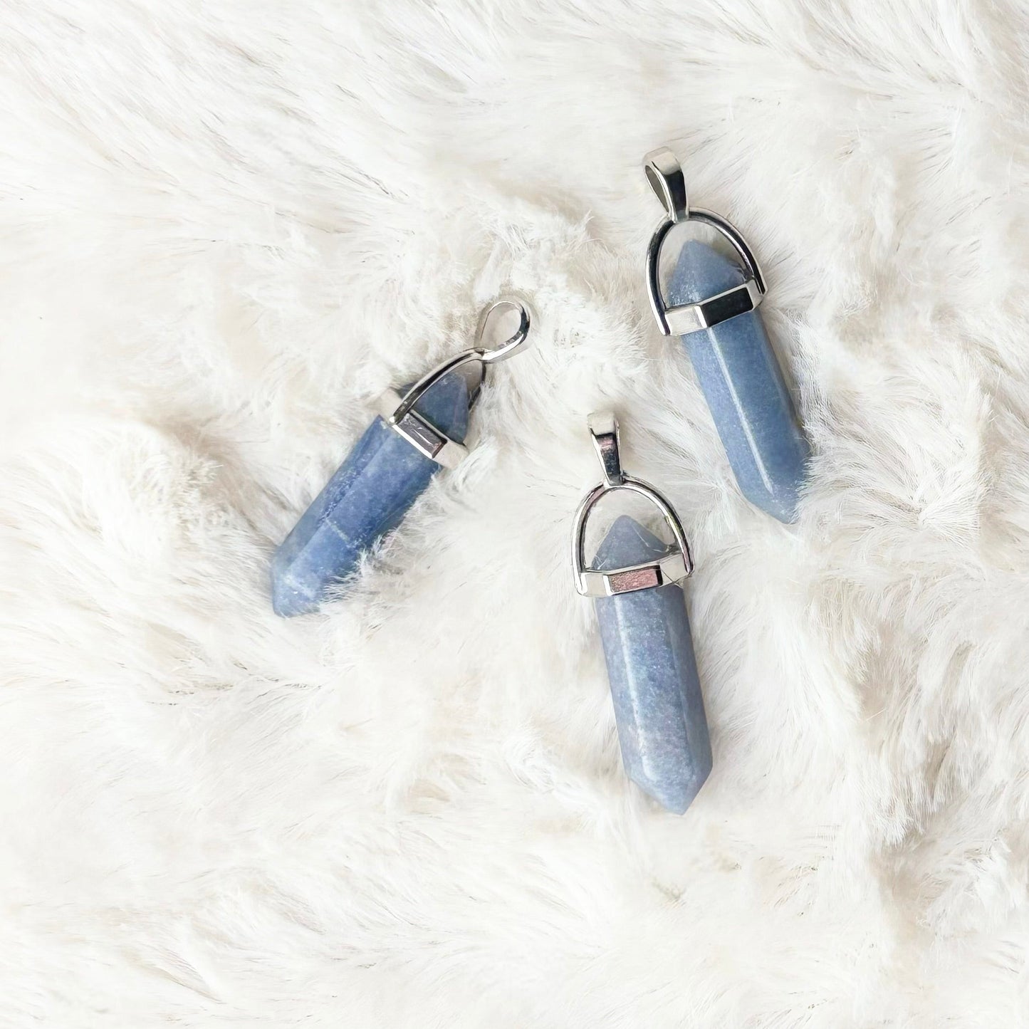 Blue crystal necklaces on a white fur surface