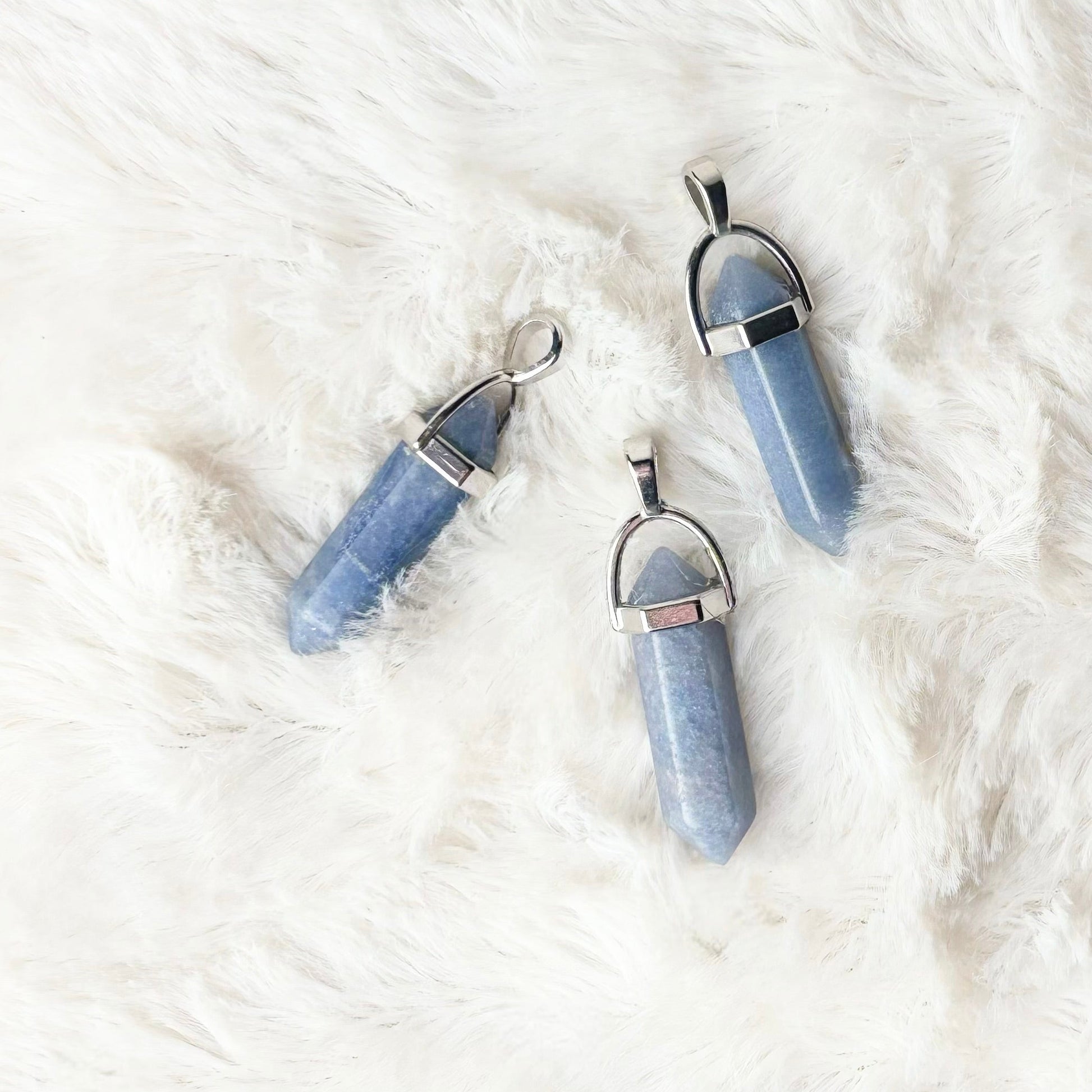 Blue crystal necklaces on a white fur surface
