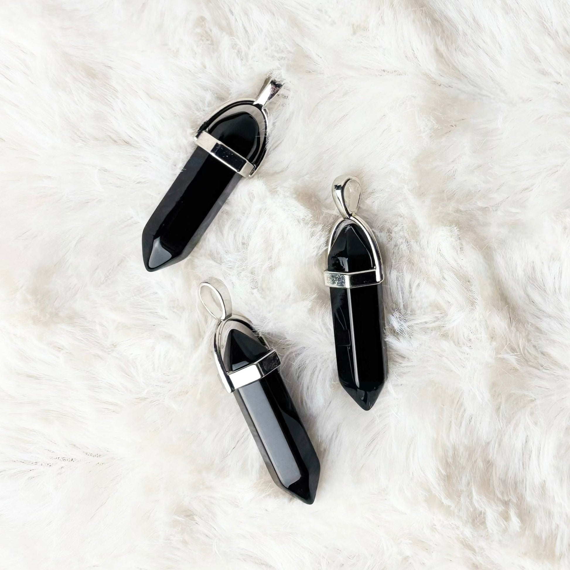 Black crystal pendants on a white fur surface