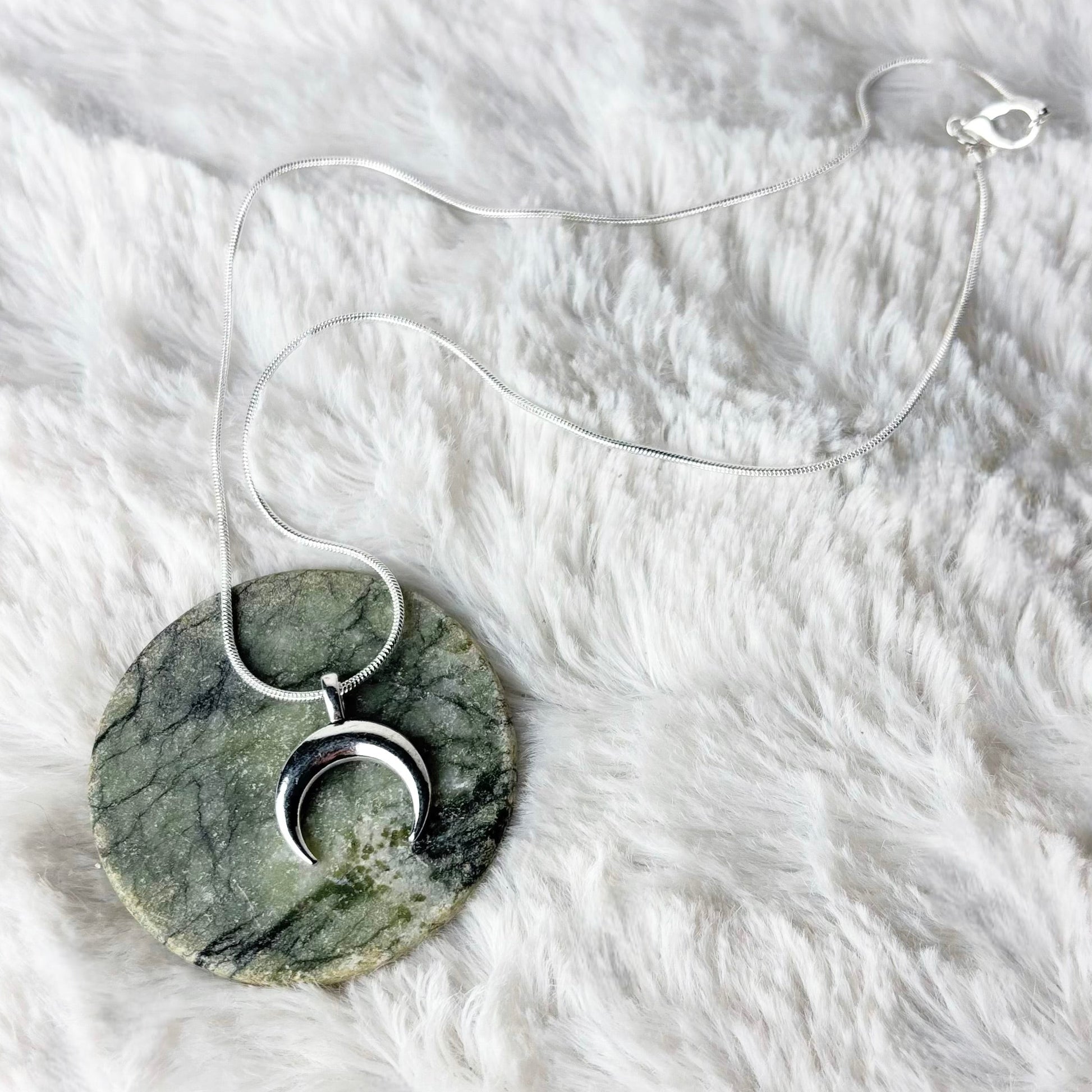 Marble pendant necklace on a white fur surface