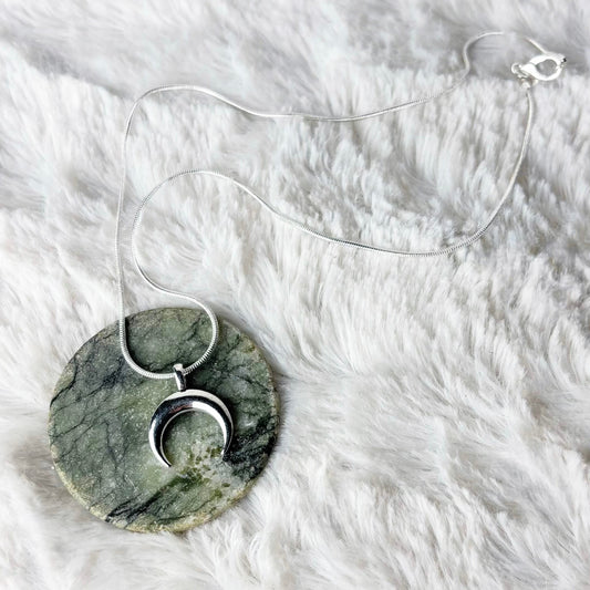 Marble pendant necklace on a white fur surface