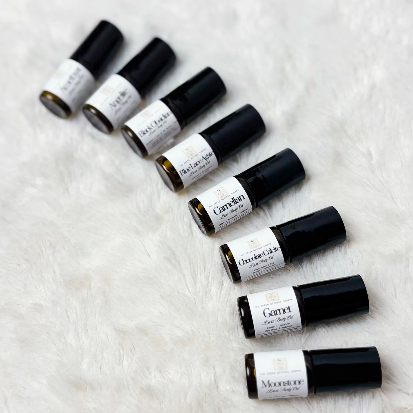 Set of black and white rollerball bottles on a textured white surface