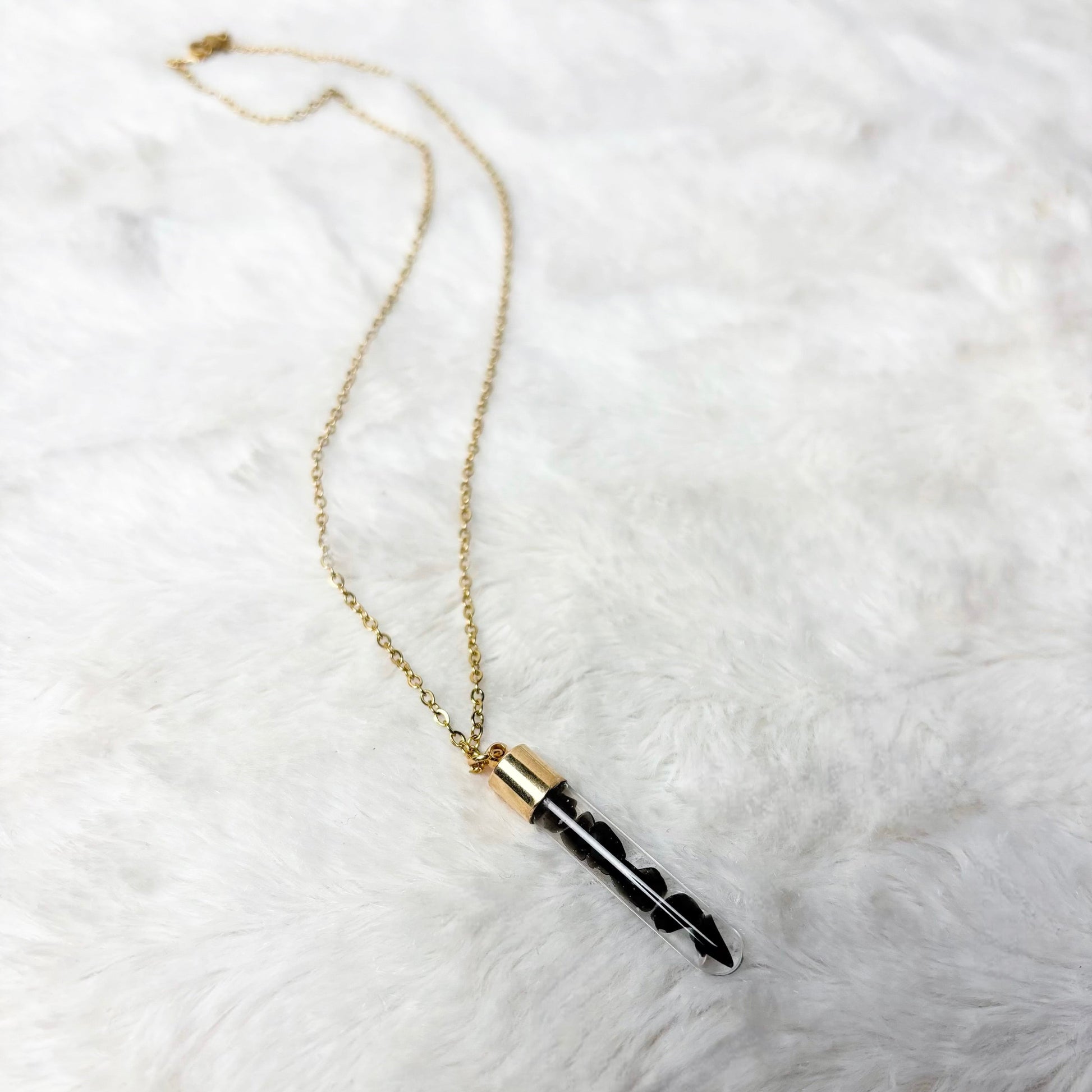 Necklace with a black pendant on a white fur surface