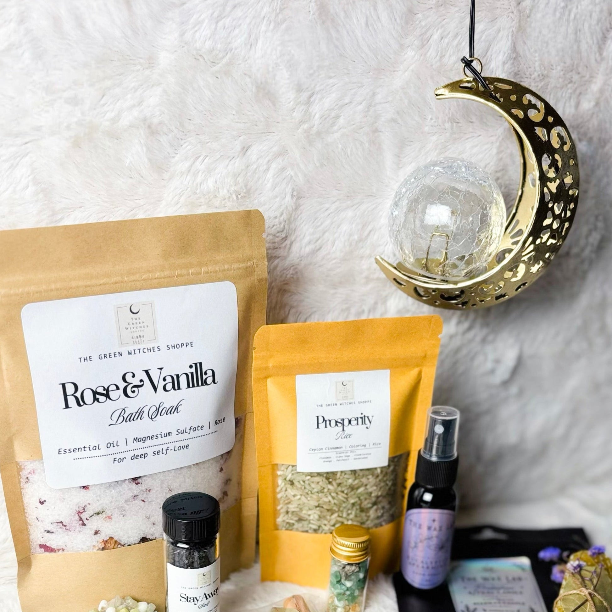 Collection of wellness products including bath salts, candles, and incense on a textured white surface.