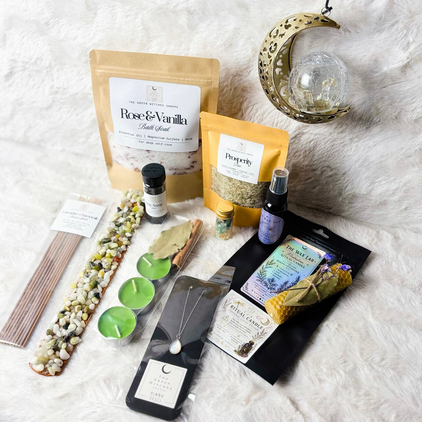 Collection of wellness products including bags, bottles, and candles on a textured surface.