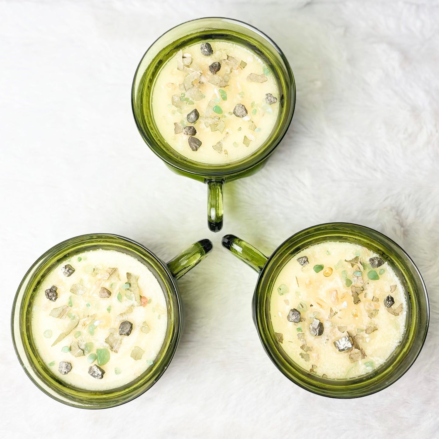 Candles with stones in a green glass cup