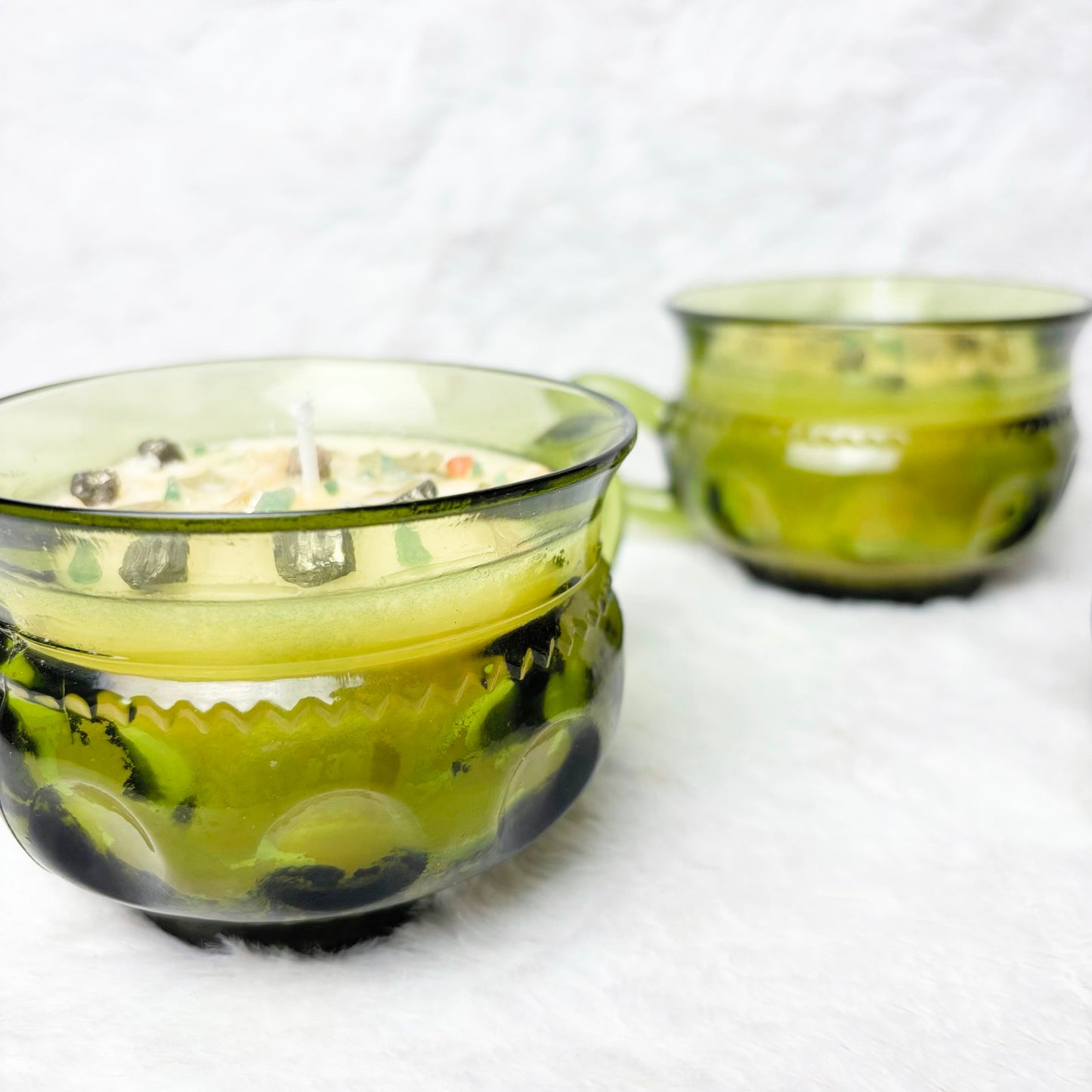 Candles with stones in a green glass cup