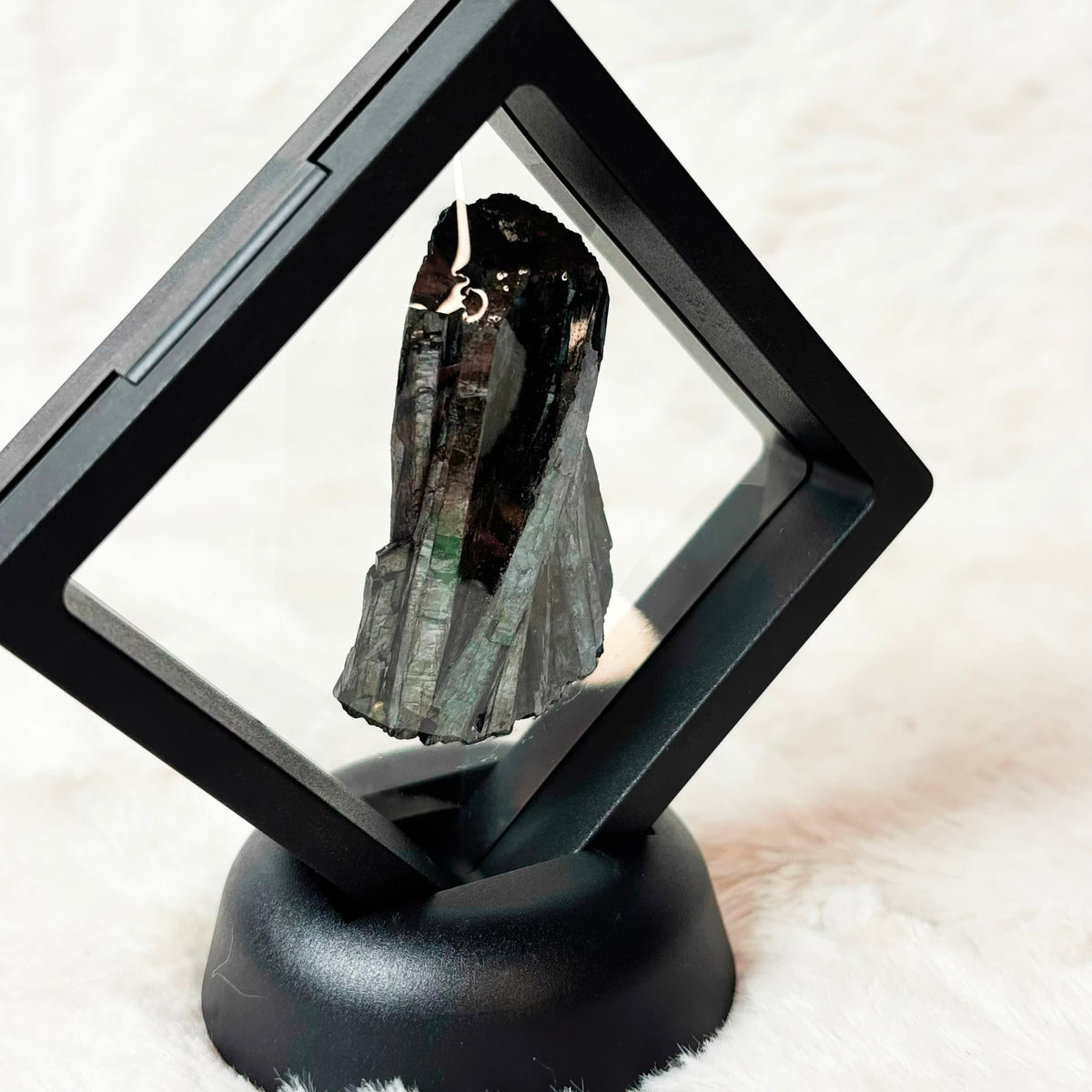 Framed Vivianite specimen on a white background