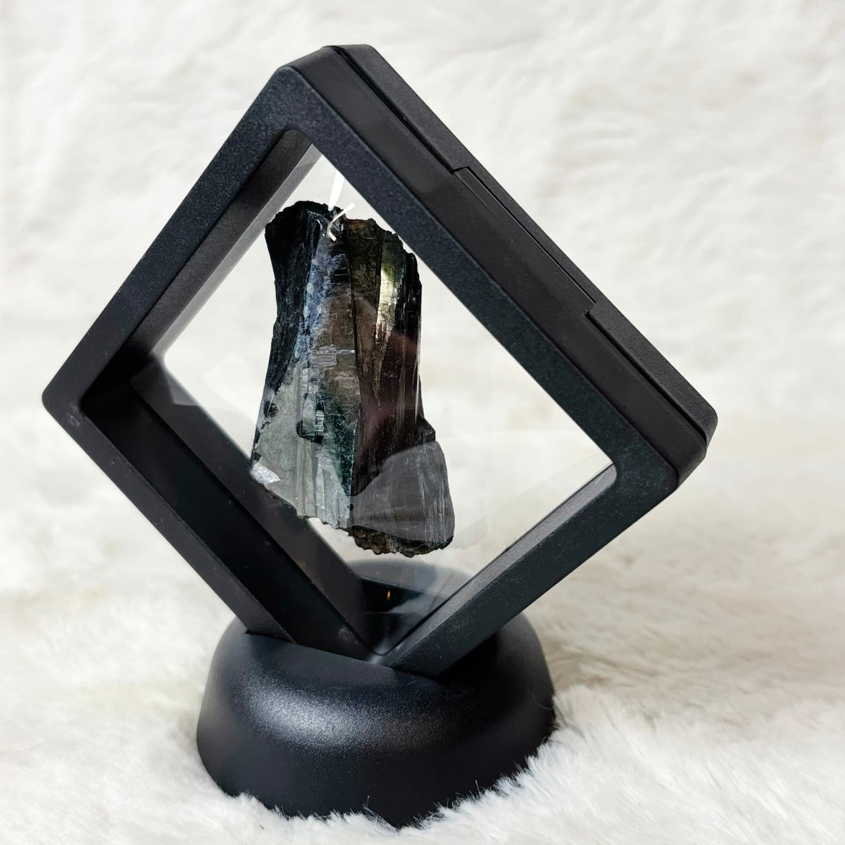 Framed Vivianite specimen on a white background
