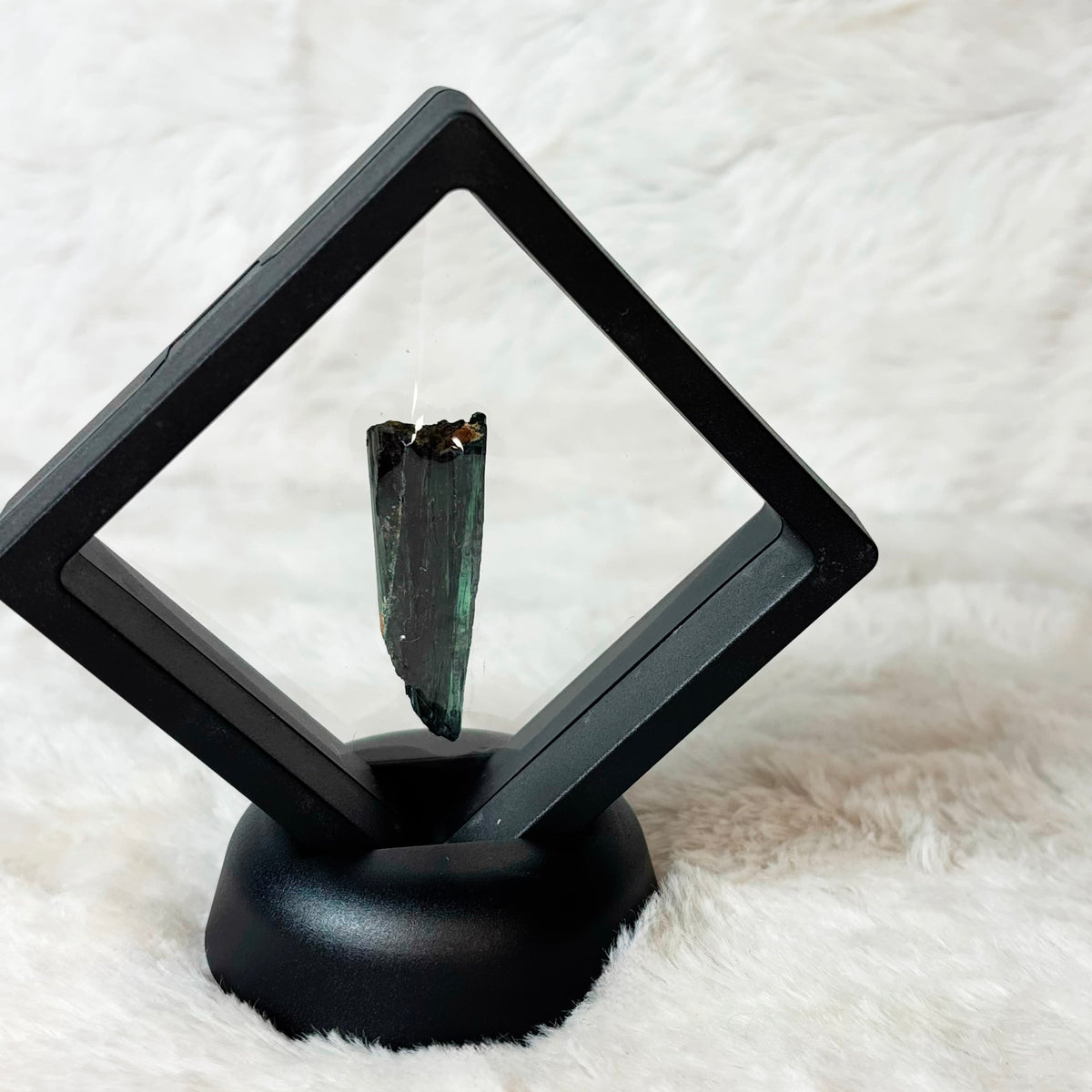 Framed Vivianite specimen on a white background