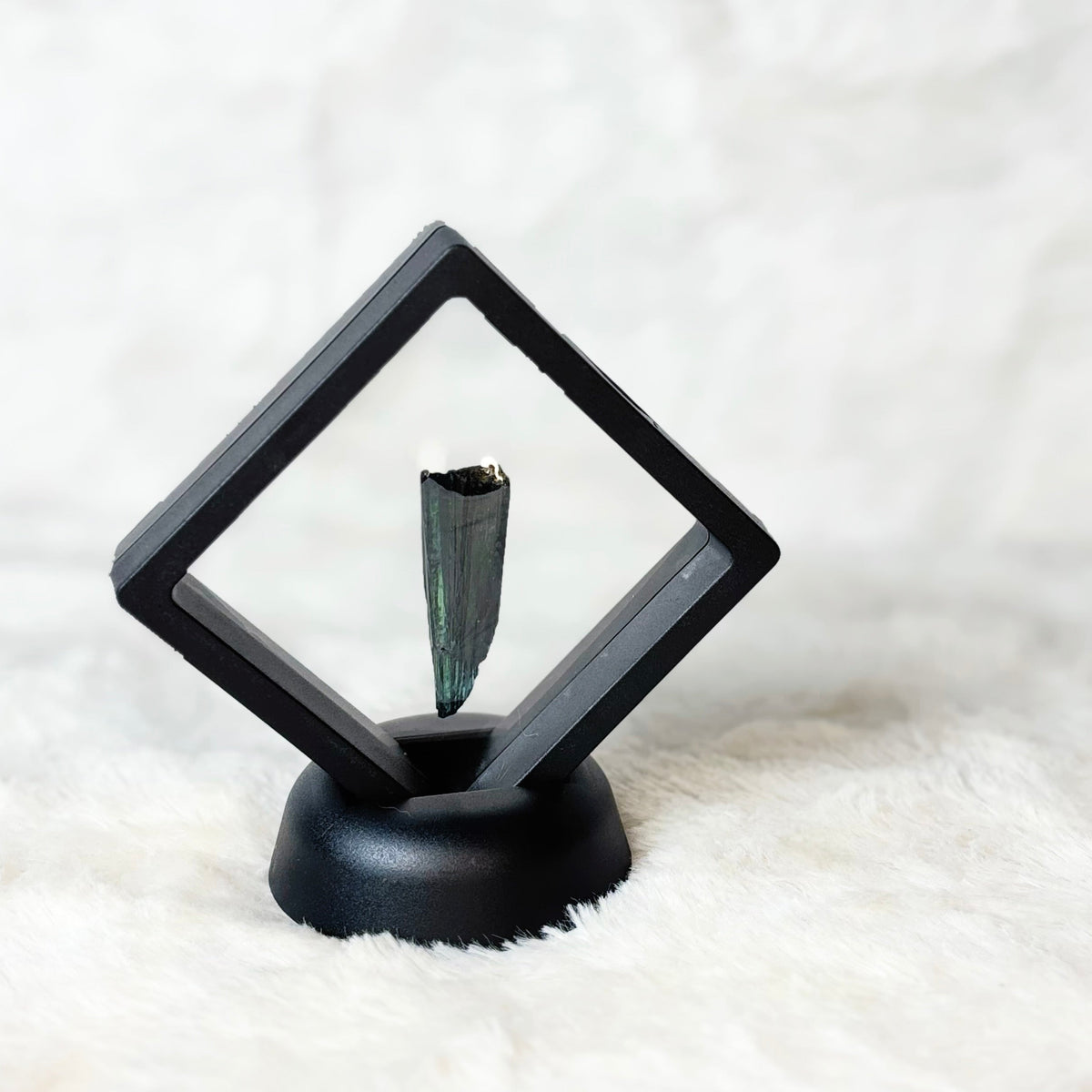 Framed Vivianite specimen on a white background