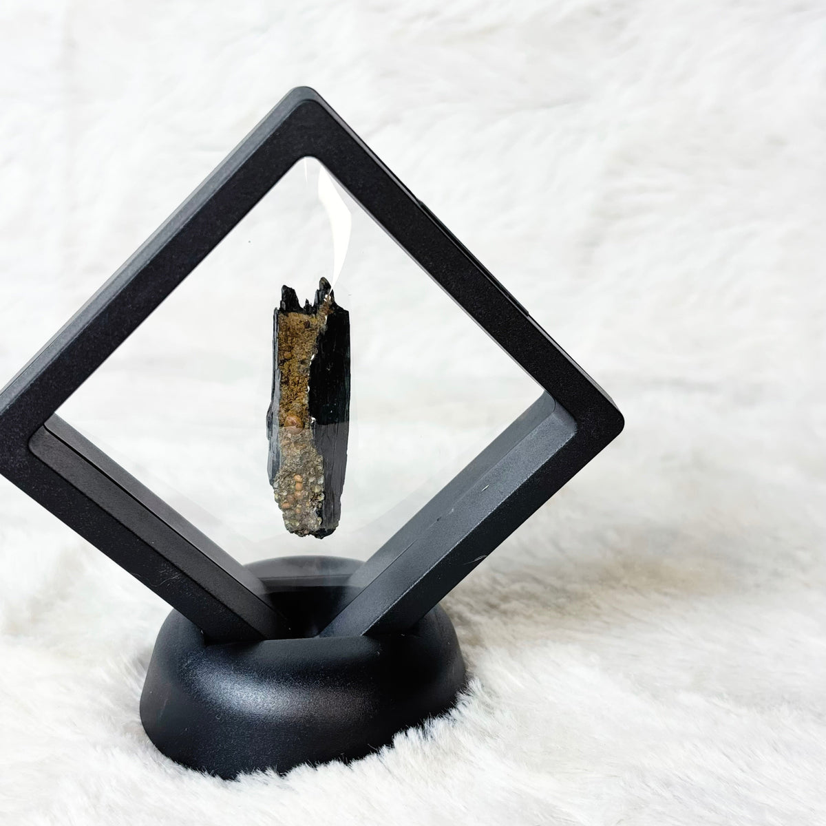 Framed Vivianite specimen on a white background