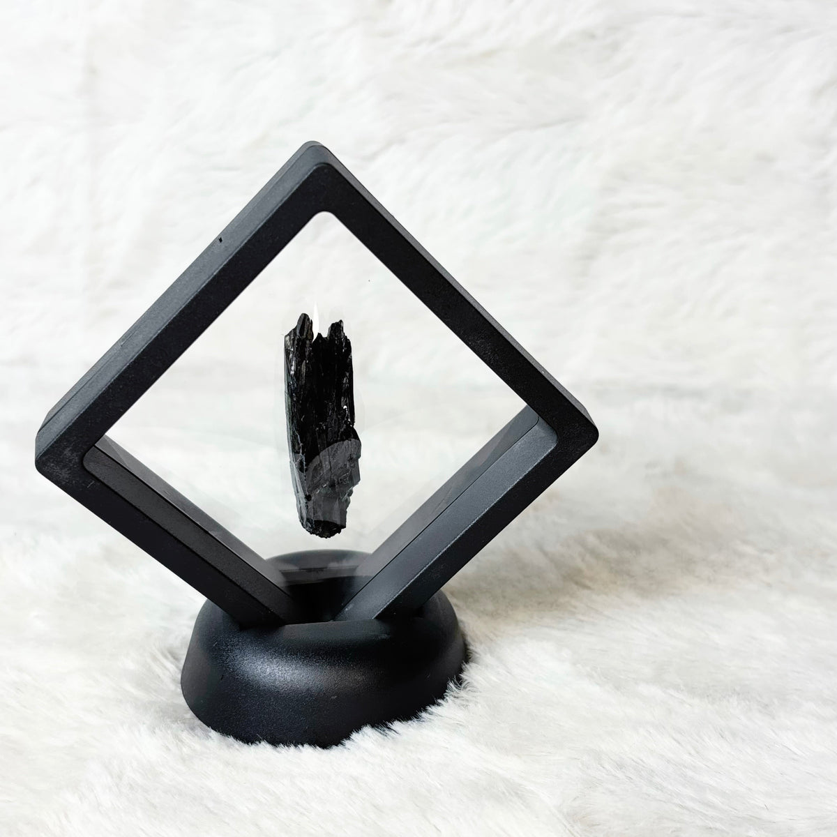 Framed Vivianite specimen on a white background
